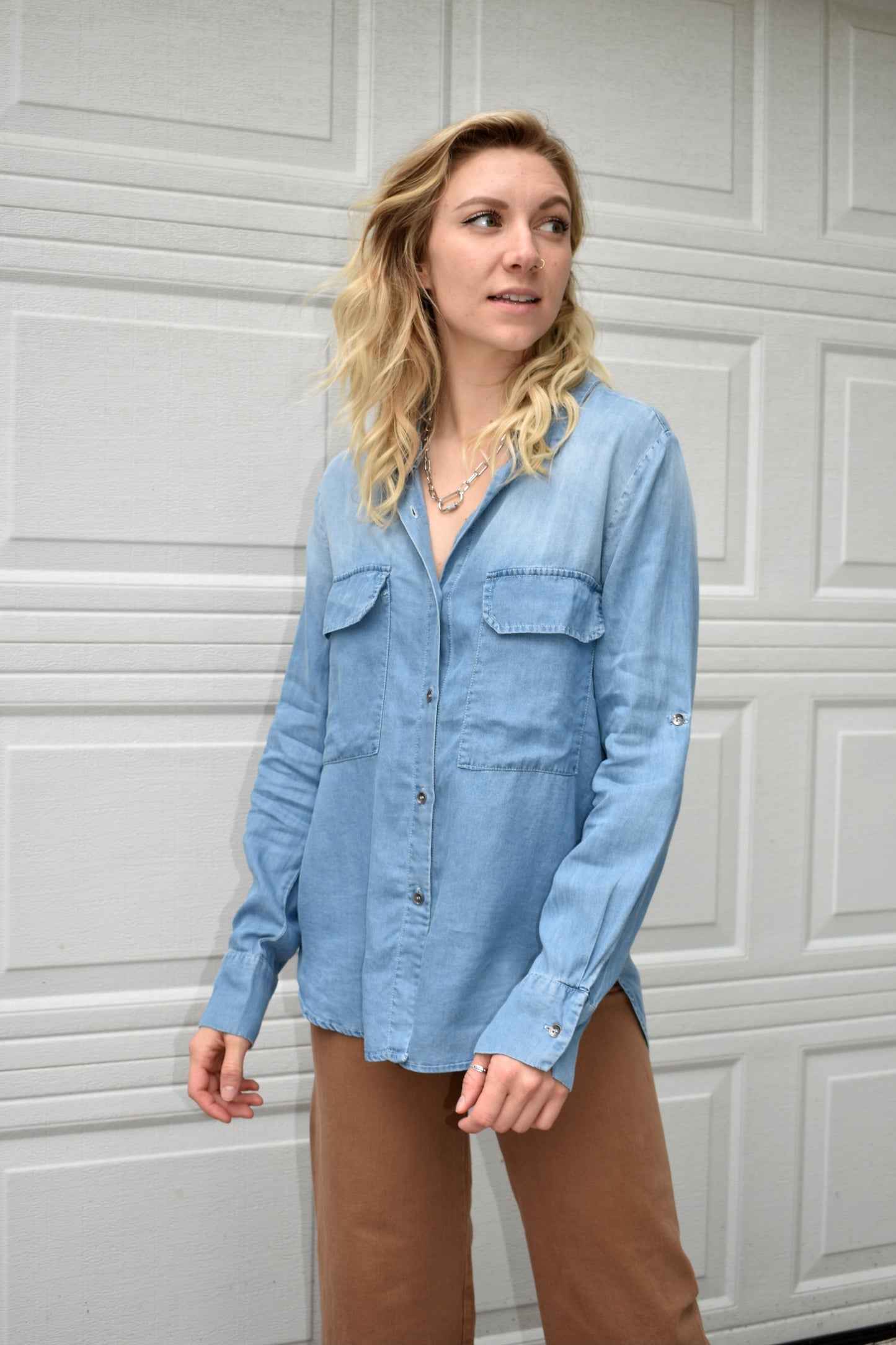 denim colored 100% tencel button down shirt. lapel collar, long camp sleeves, and front patch pockets with flaps. the brand is miss love.