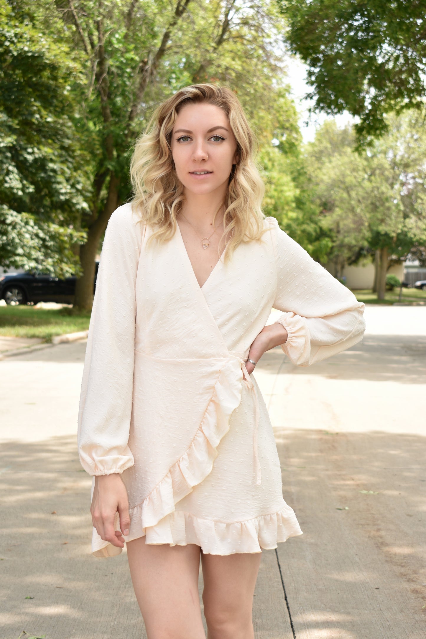 Cream swiss dot textured mini wrap dress with long billow sleeves and ruffled hem