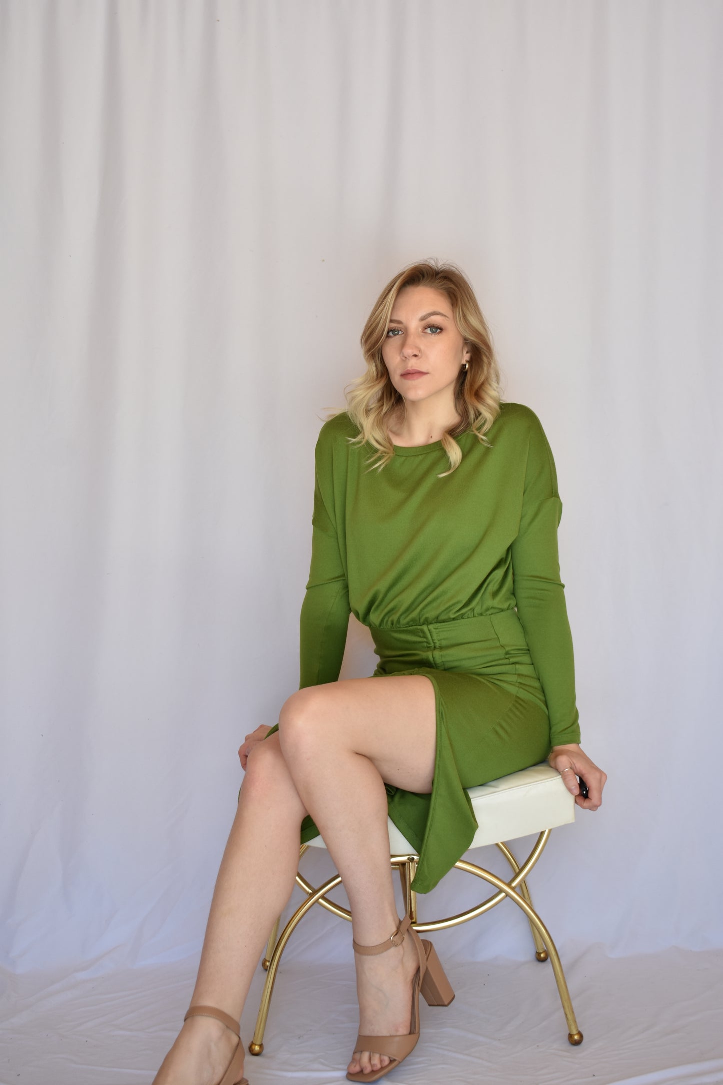 long sleeve avocado green midi dress with boat neck and relaxed bodice that transitions into a bodycon fit with synching drawstring that goes into a side slit.