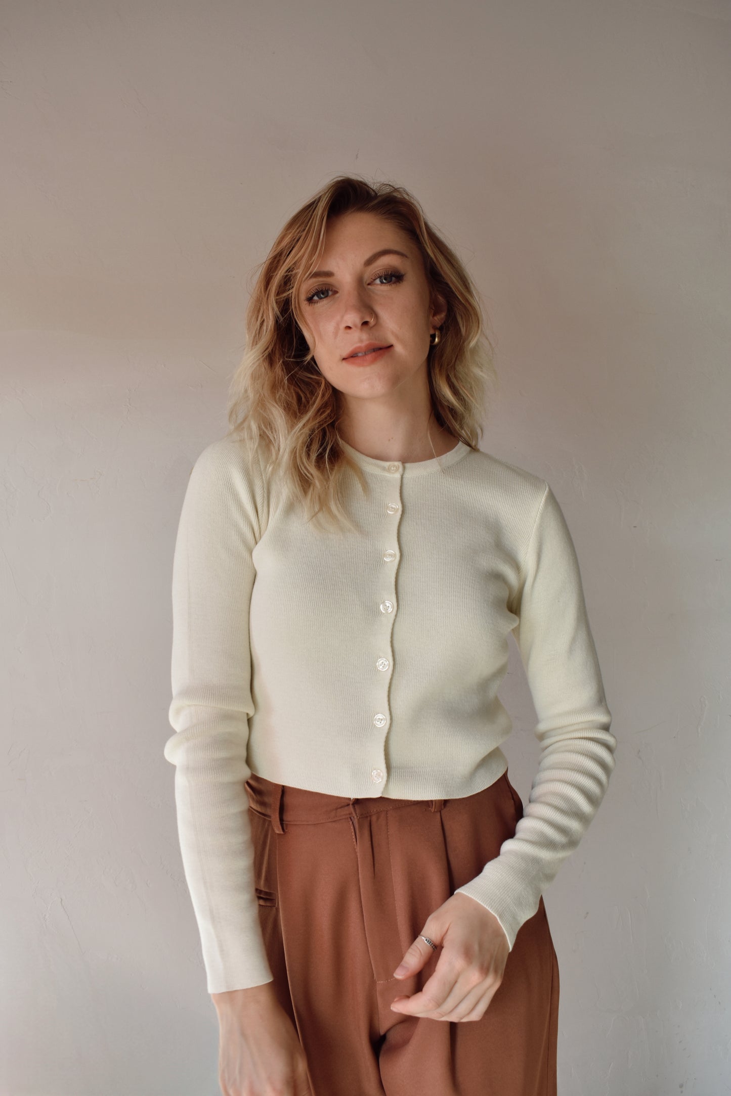 fitted ribbed knit full button cardigan. waist length crew neck when buttoned. cream color