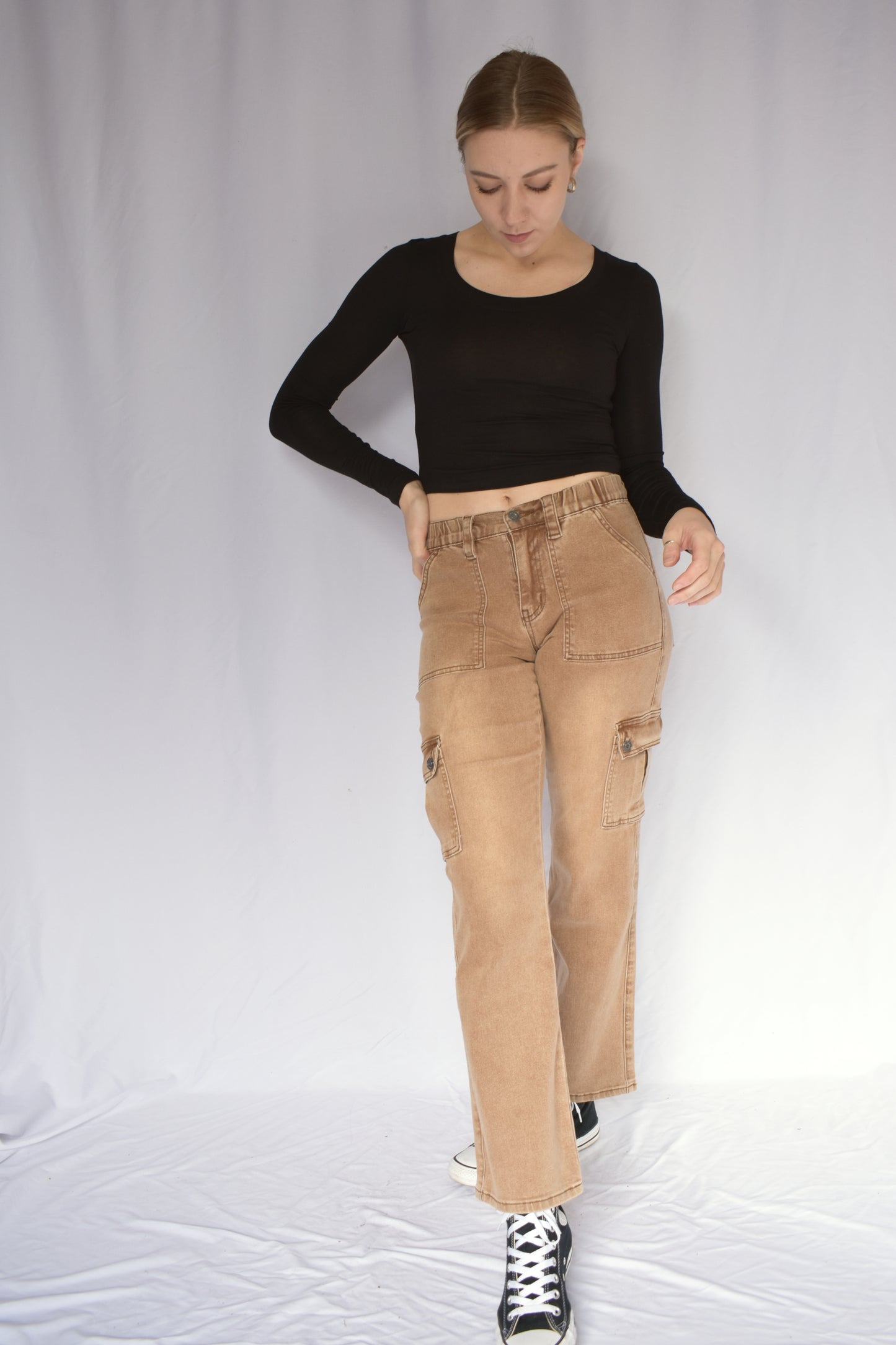Tan stretch cargo jeans with side pockets with button enclosure and front patch pockets. also pockets on the back. elastic waist. straight leg. mid rise.