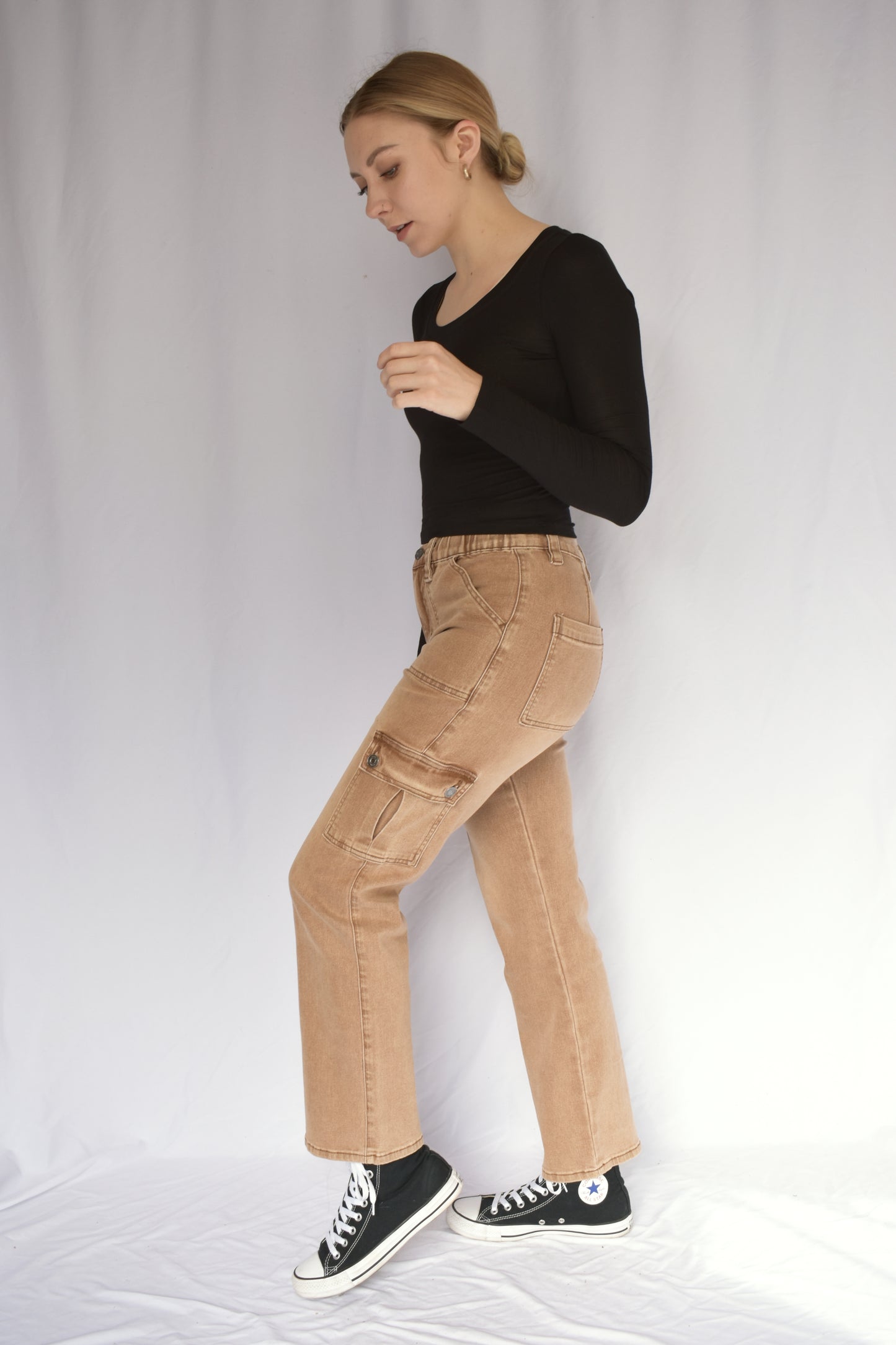 Tan stretch cargo jeans with side pockets with button enclosure and front patch pockets. also pockets on the back. elastic waist. straight leg. mid rise.