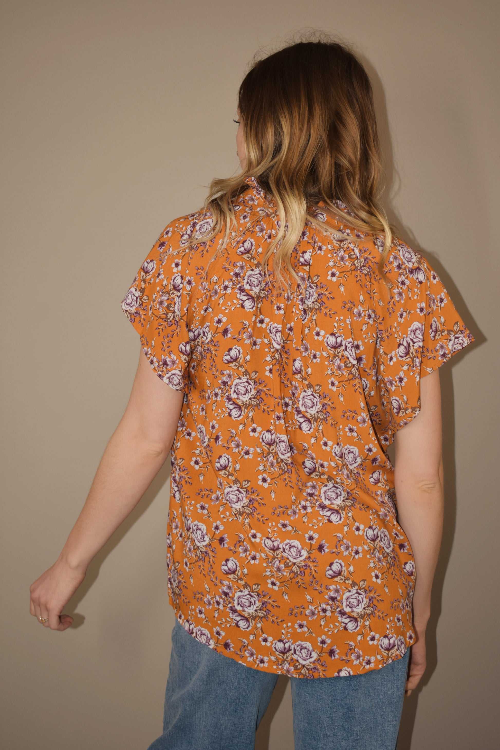 tangerine button down relaxed fit blouse with white and purple floral pattern. ruffle collar. flutter cap sleeves. full length