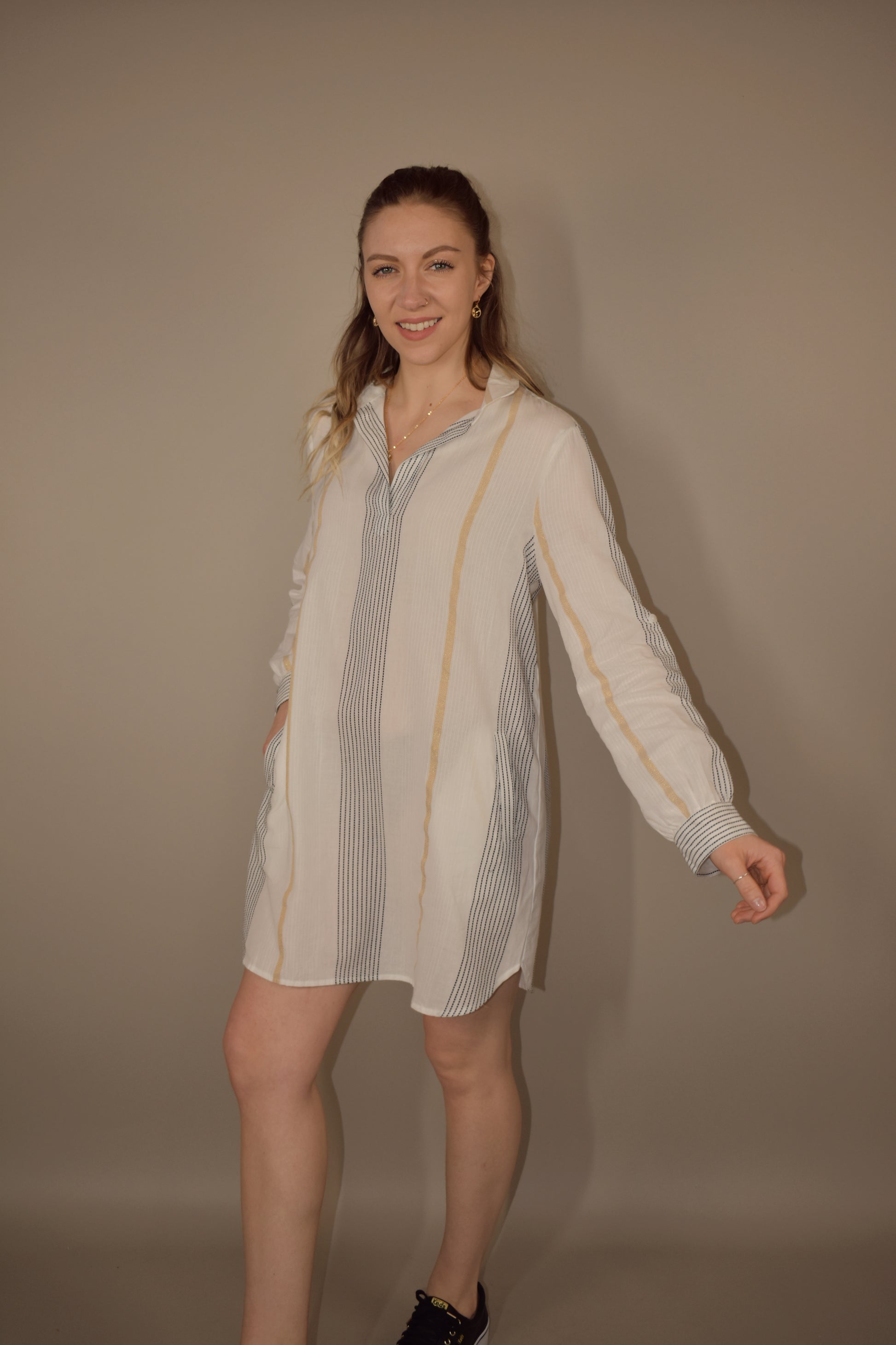 long sleeve mini shirt dress. white with taupe and black vertical stripes. pockets in front. collared and v neck. 