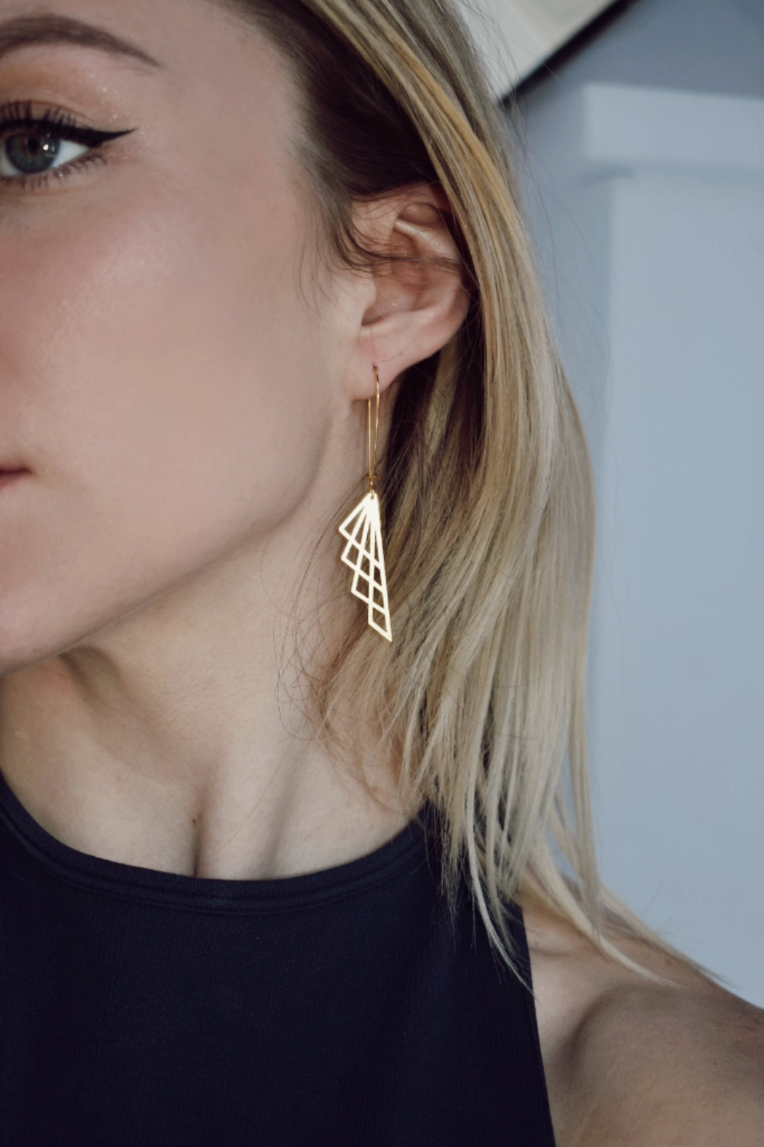 geometric laser cut brass pendants on gold plated elongated earwires edgy gold earrings