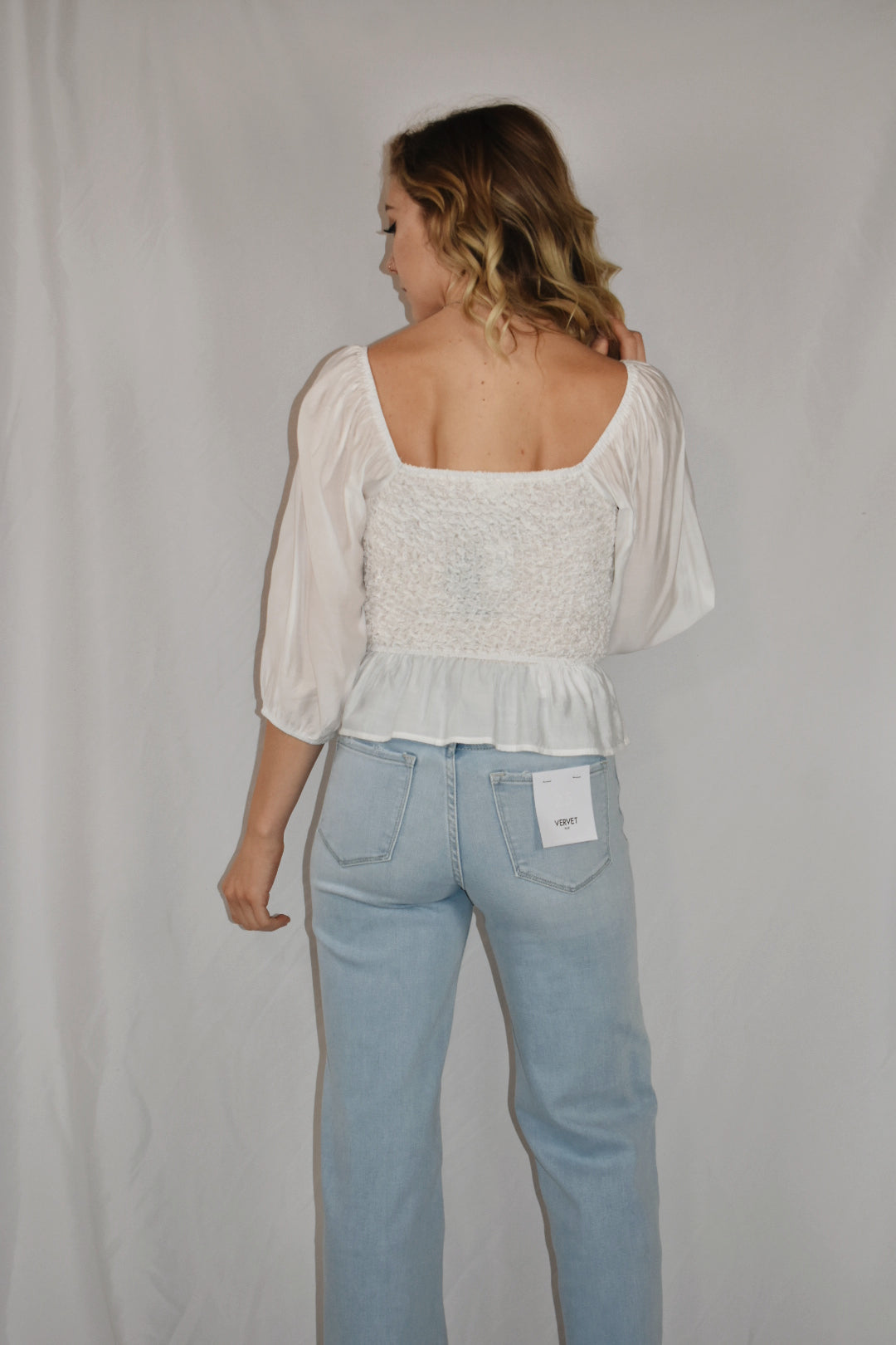 white blouse square neckline 3/4 length sleeves popcorn smocking detail on the bodice ruffle bottom mittoshop the revival