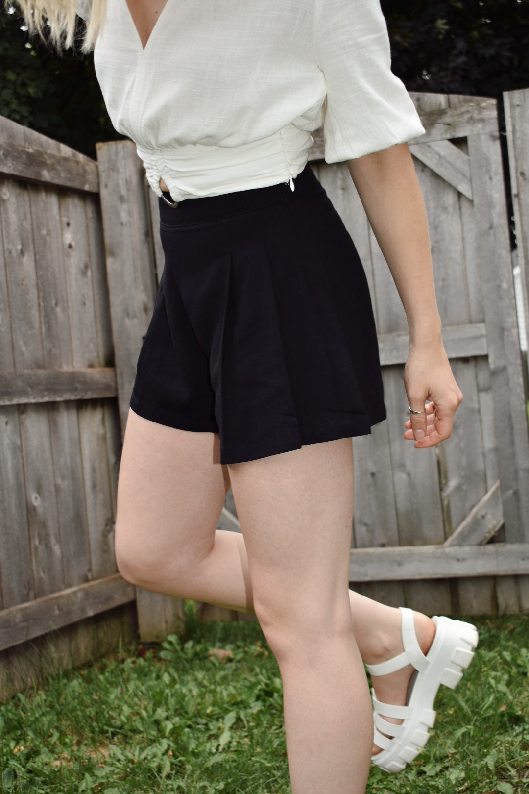 High waisted black pleated dress shorts with zipper enclosure on side fitted band on top. The brand is Mittoshop.
