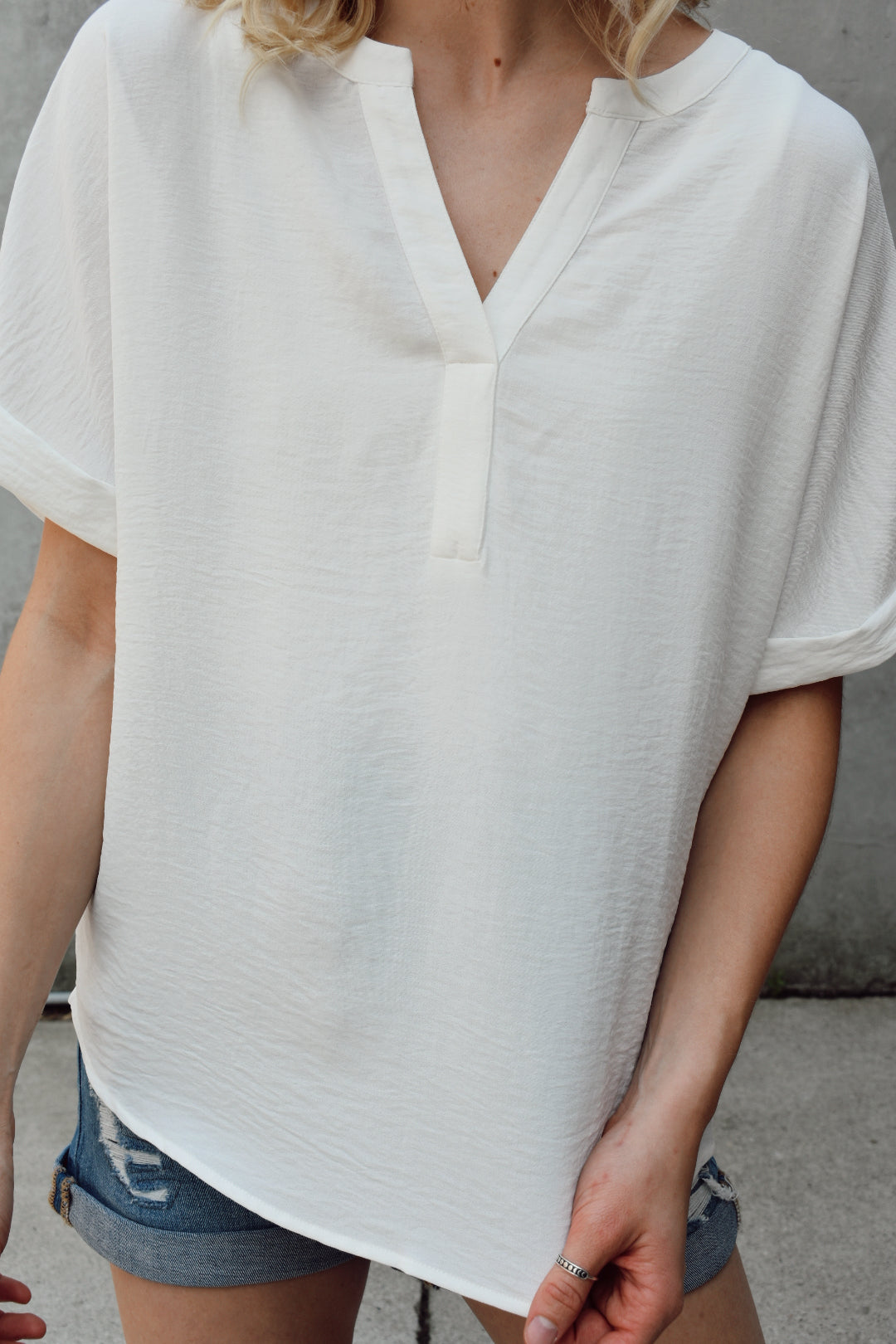 lightweight full length white loose fitted blouse. Has a round neck with a V-neck placket detail front, the dolman short sleeves feature cuff bands. The brand is Mittoshop