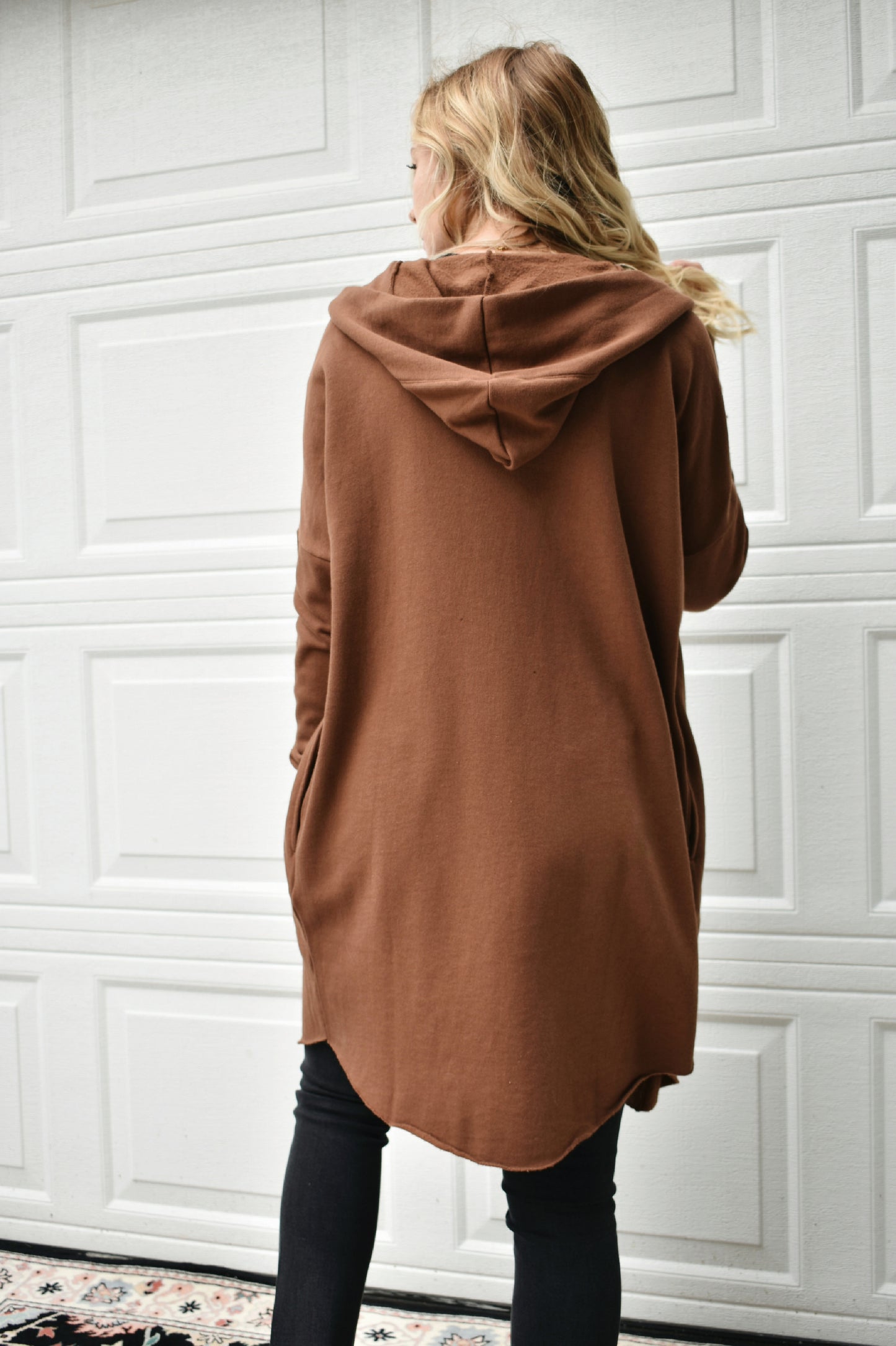 Cocoa colored hooded jersey cardigan with wide cuffed sleeves, an open front, and pockets. fleece lining. 100% cotton