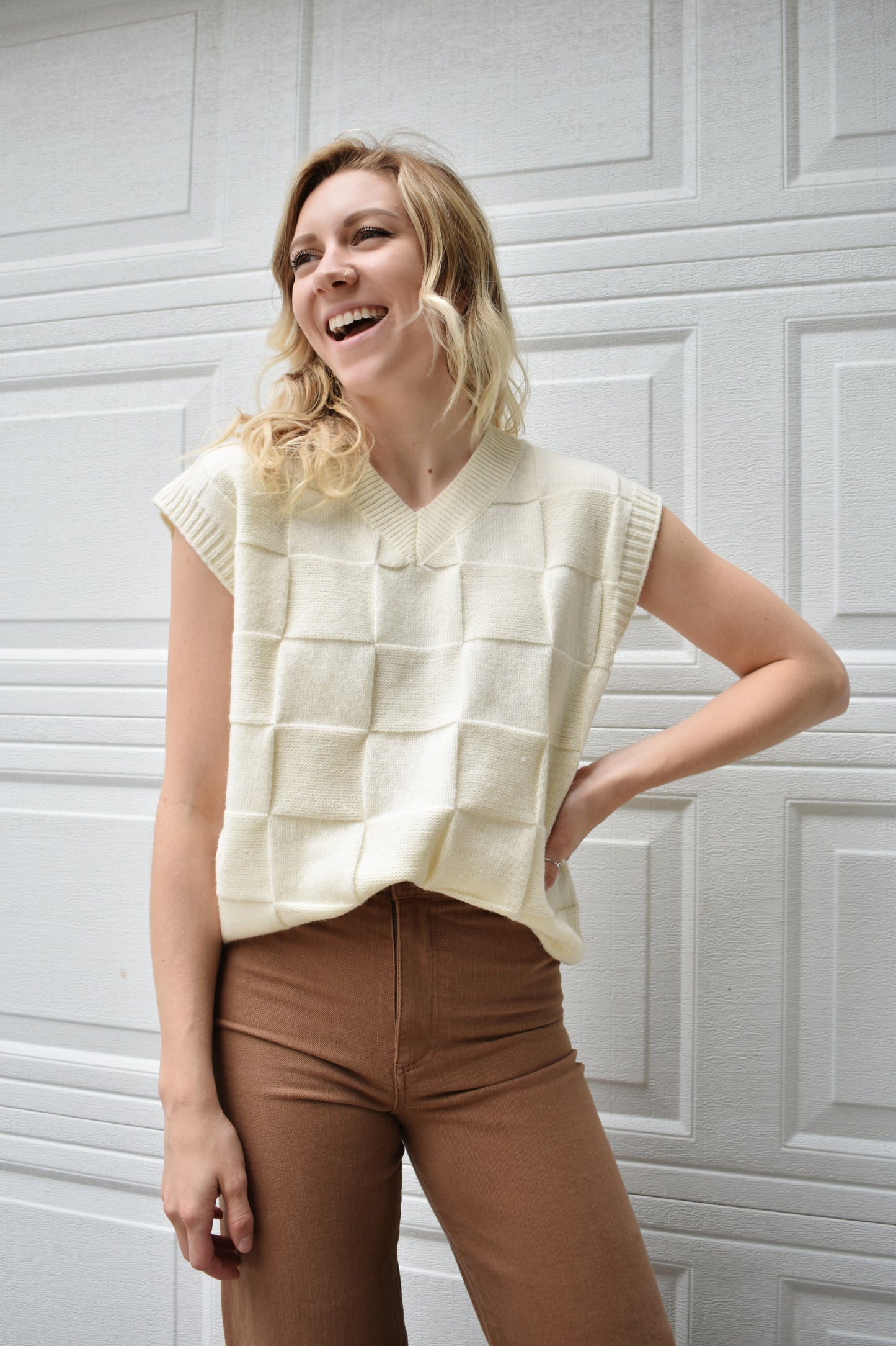 cream sweater vest with knit basket weave fabric and ribbed neckline, shoulders, and hem. V-neckline and waist-length cut