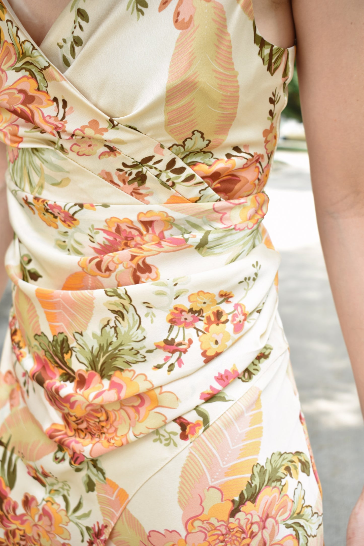 Floral printed satin midi dress with surplice neckline and adjustable spaghetti straps. Left side slit with shirred sides.