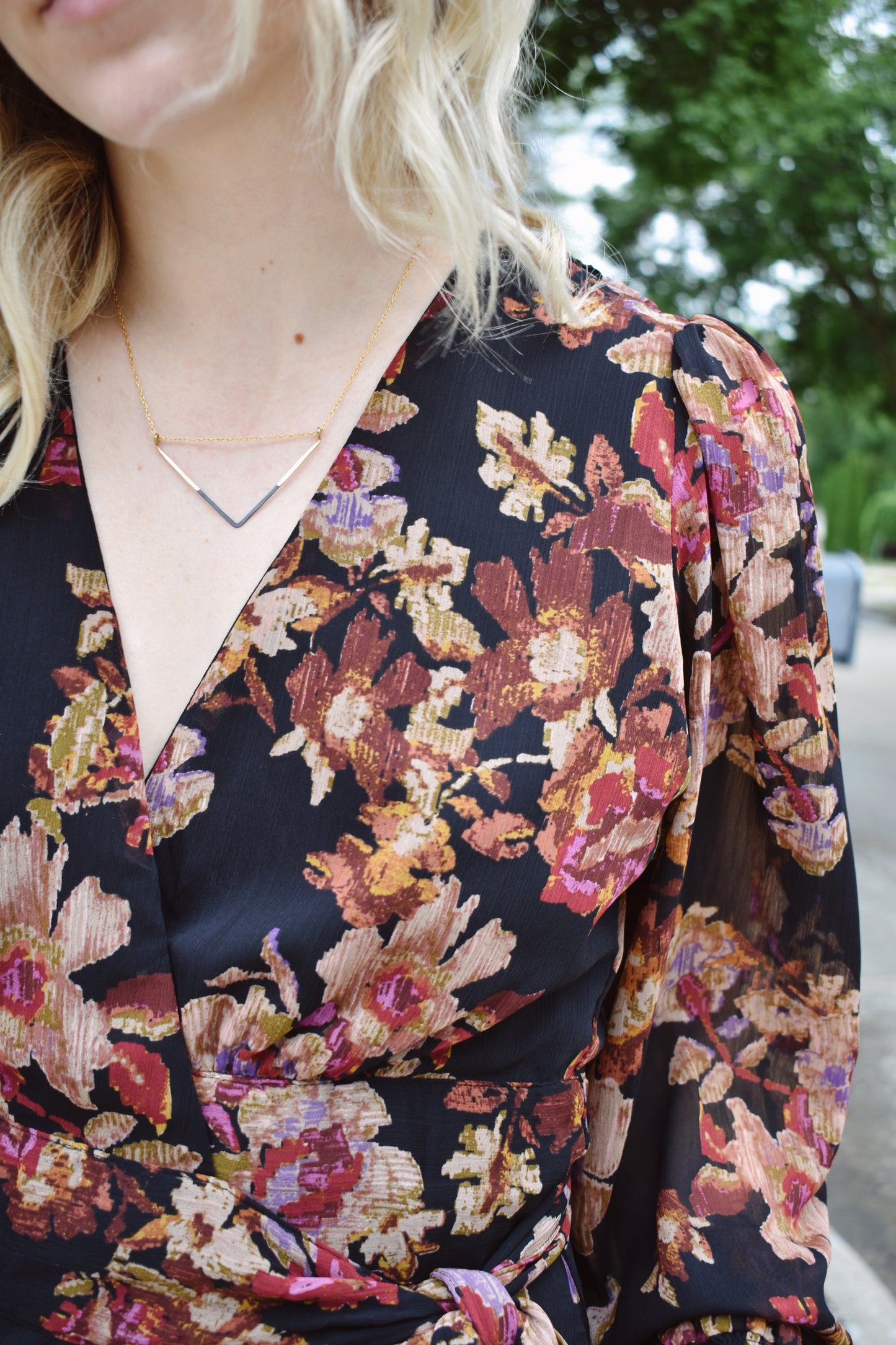 Floral print wrap mini dress with long bishop sleeves that have a smocked opening. Ruffle edged hem.