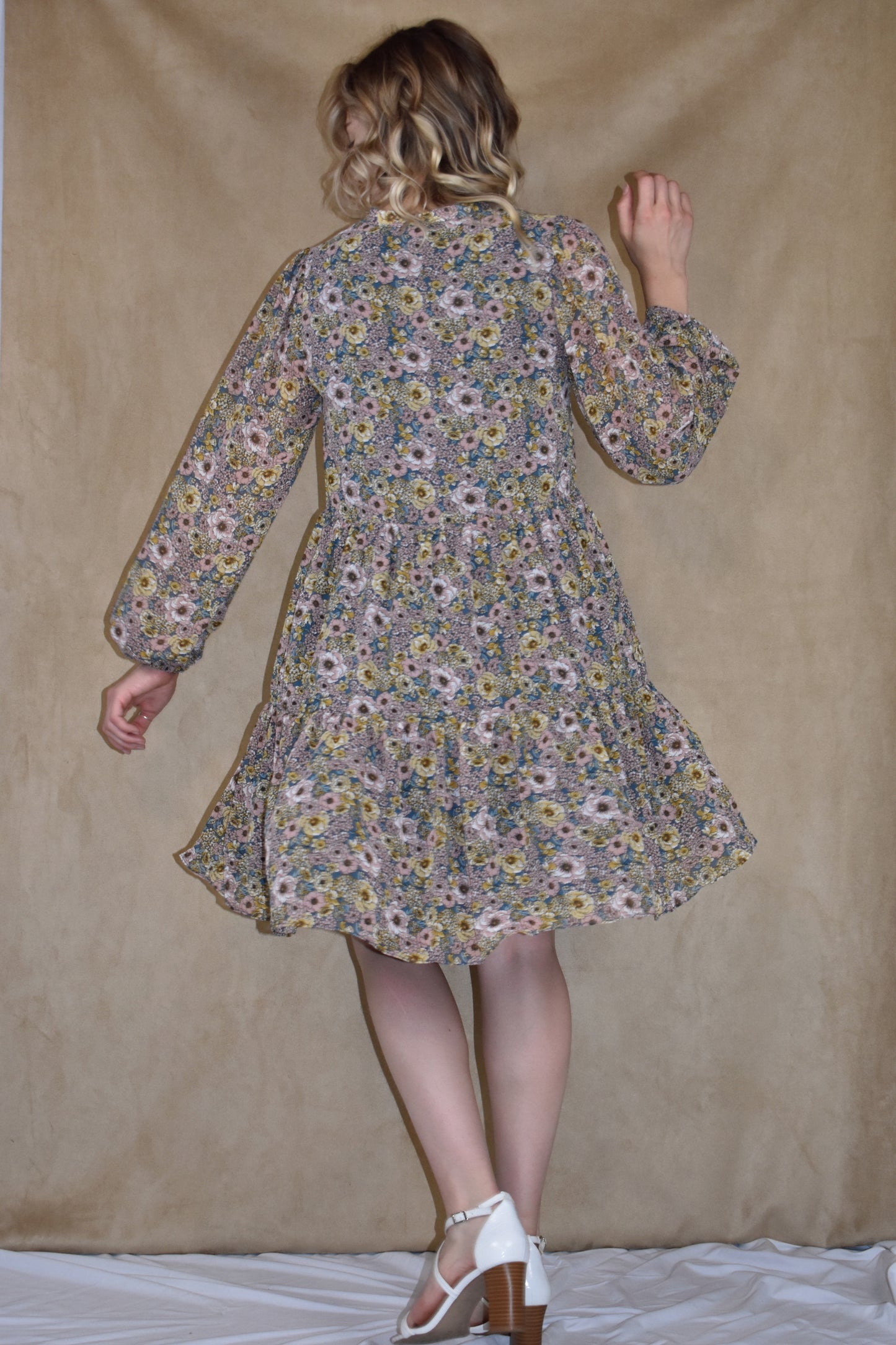 long sleeve mini dress loose fitted, vintage floral pattern, round neckline, slit front and placket with button front closure. ruffle tier skirt