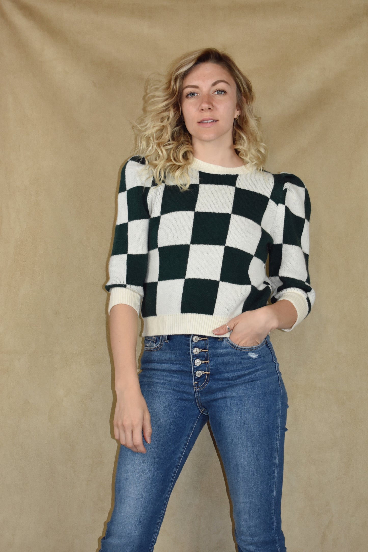 checkered green and cream sweater with ribbed crew neckline, hem, and cuffs. Puff shoulders and elbow length sleeves.