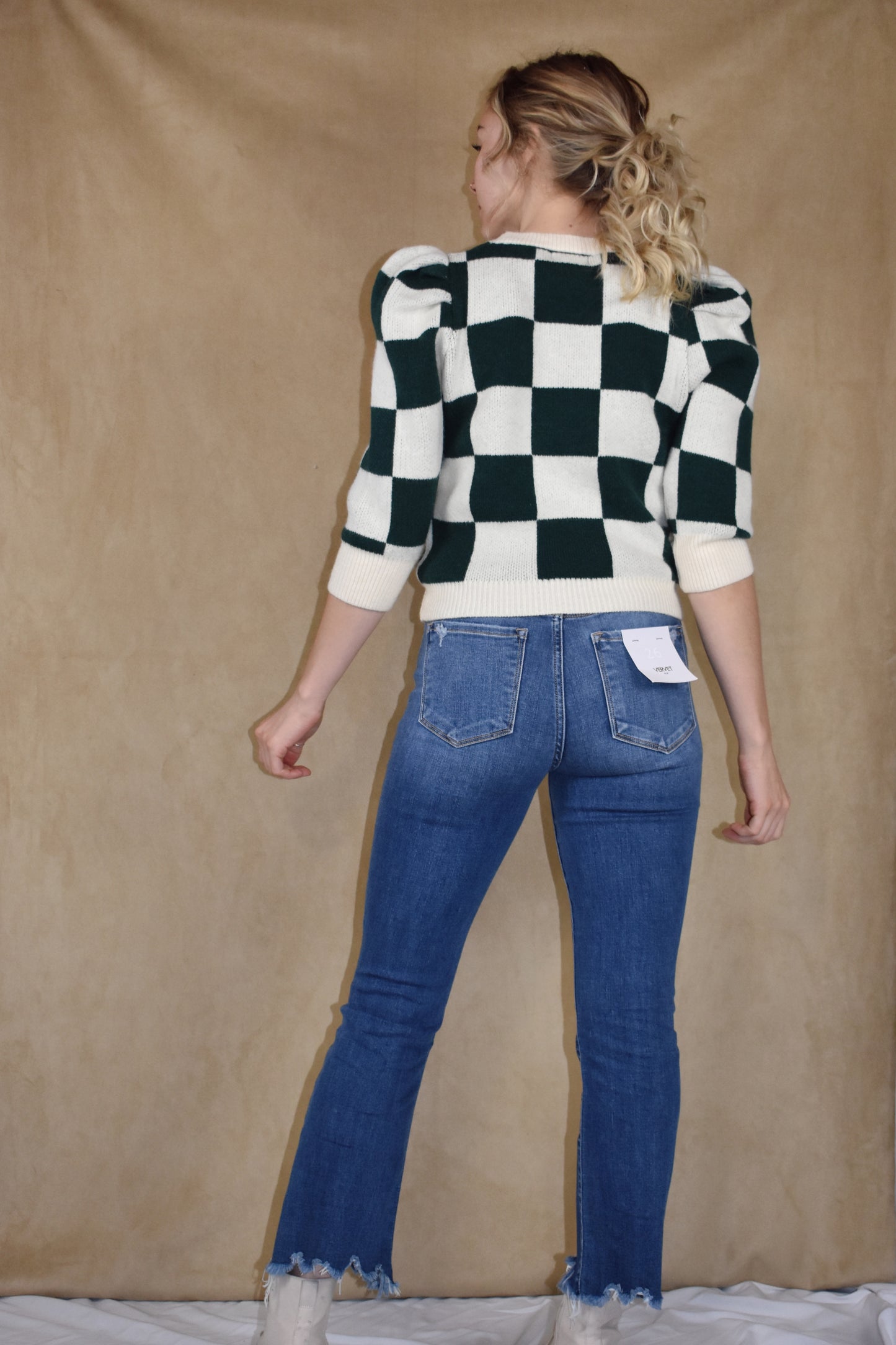 checkered green and cream sweater with ribbed crew neckline, hem, and cuffs. Puff shoulders and elbow length sleeves.