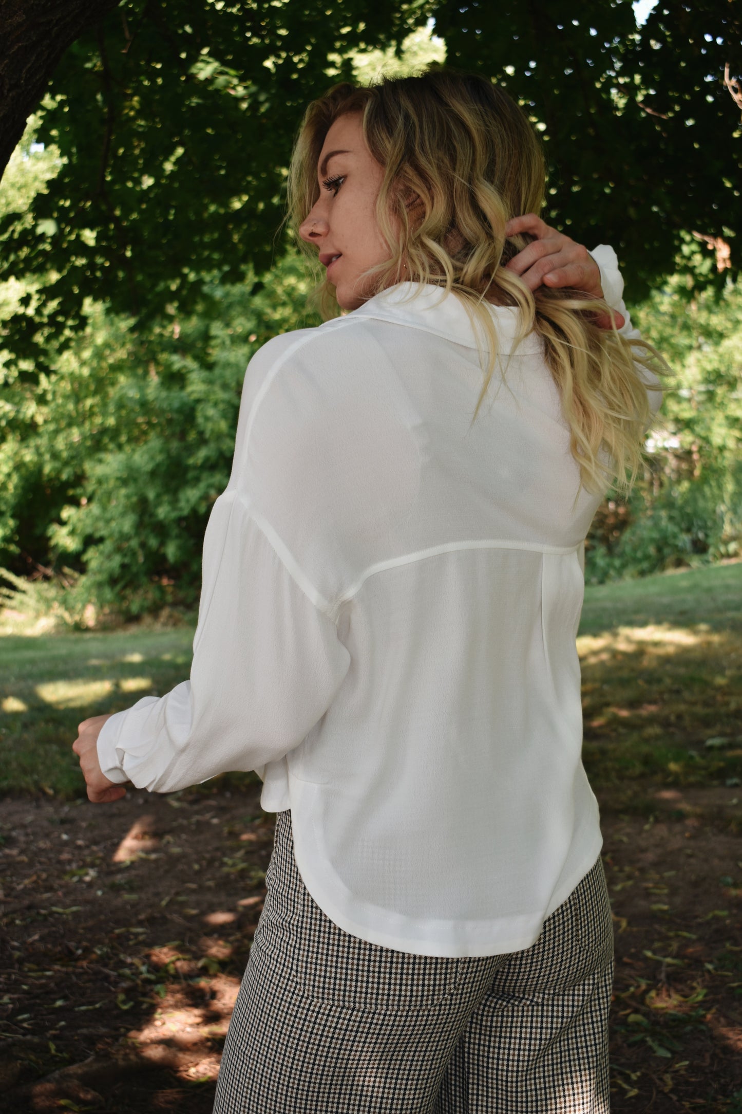 white button down top with cuffed bands and a collar. Placket front with button closure and a cropped length.