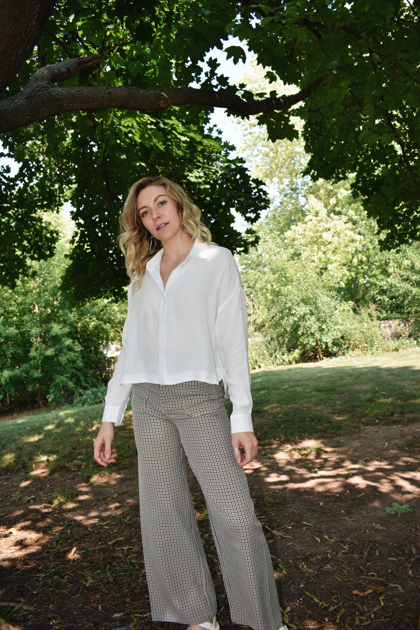 white button down top with cuffed bands and a collar. Placket front with button closure and a cropped length.