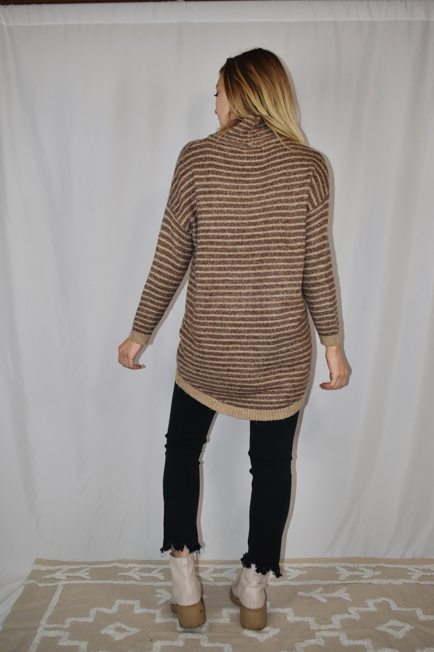 Pullover turtleneck striped sweater. Drop shoulder long sleeves, ribbed hem and sleeve cuffs, and high-low rounded hem. Dark mocha and taupe color.
