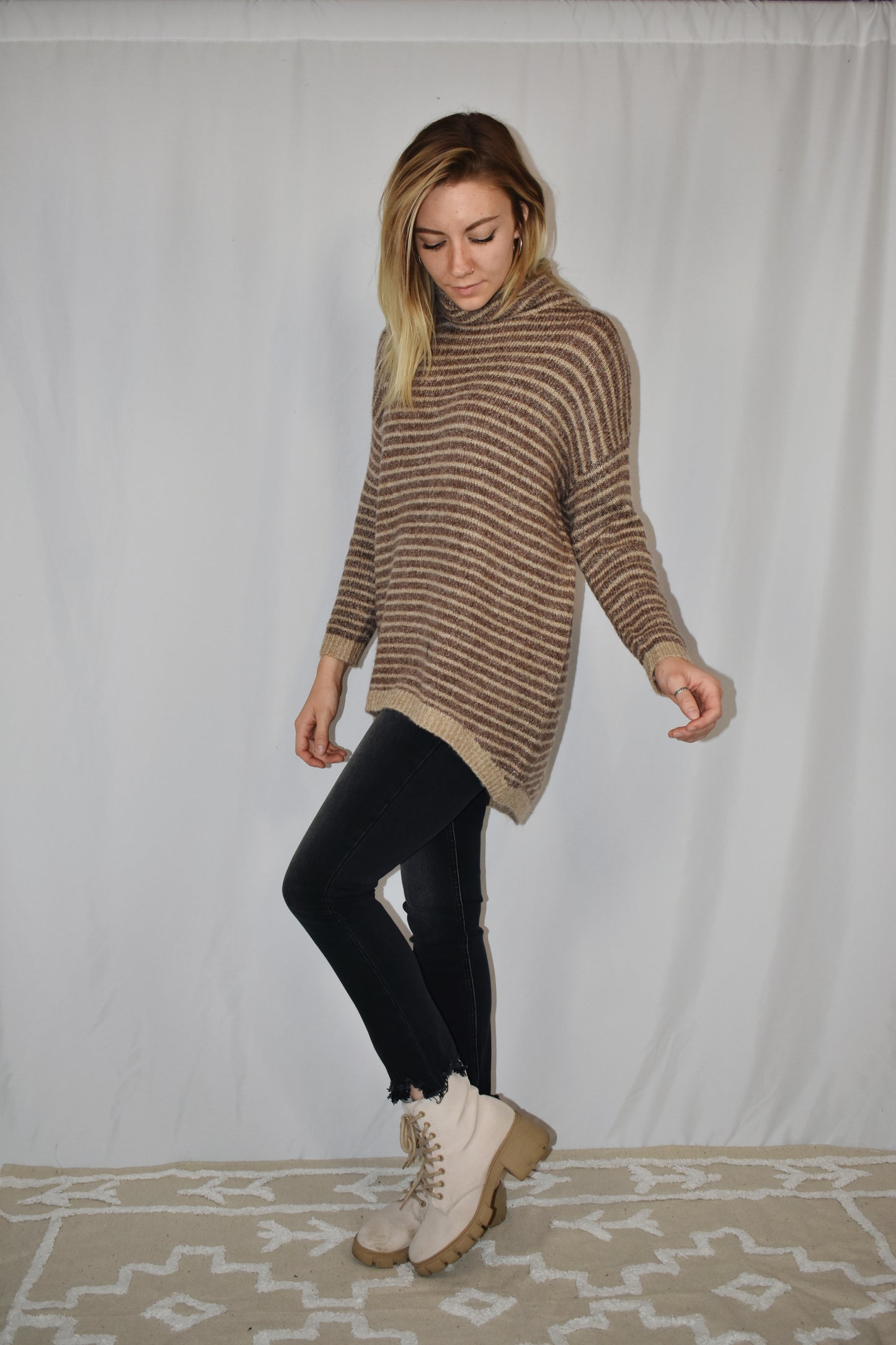 Pullover turtleneck striped sweater. Drop shoulder long sleeves, ribbed hem and sleeve cuffs, and high-low rounded hem. Dark mocha and taupe color.