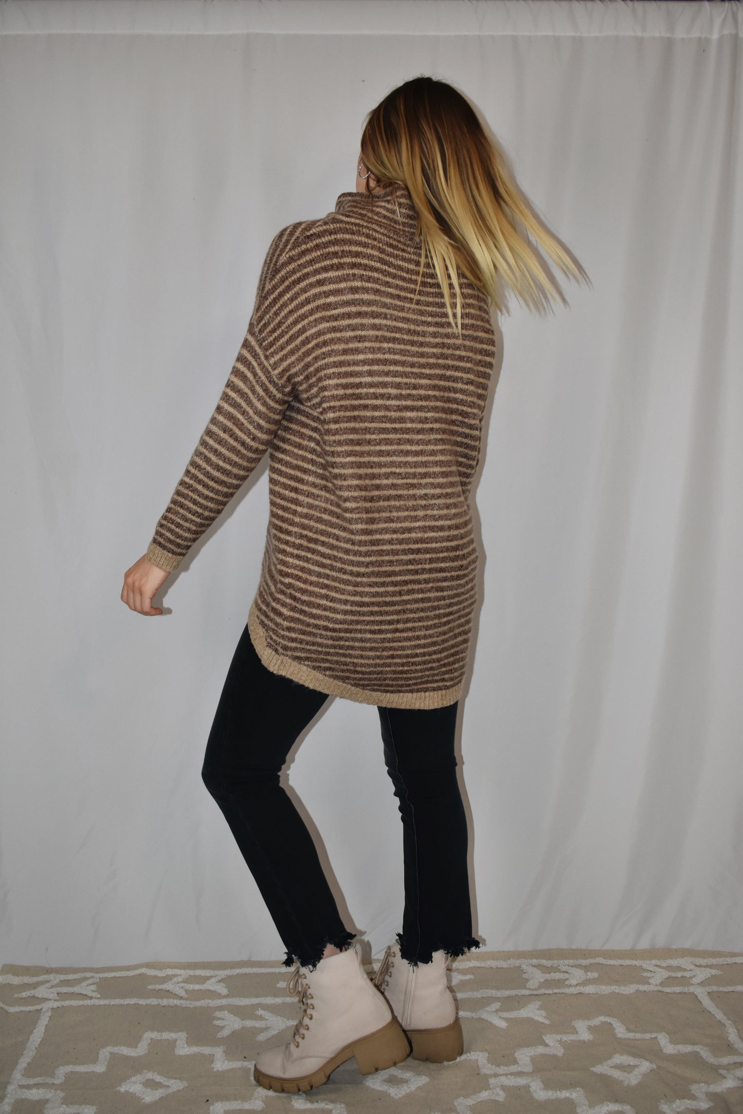Pullover turtleneck striped sweater. Drop shoulder long sleeves, ribbed hem and sleeve cuffs, and high-low rounded hem. Dark mocha and taupe color.