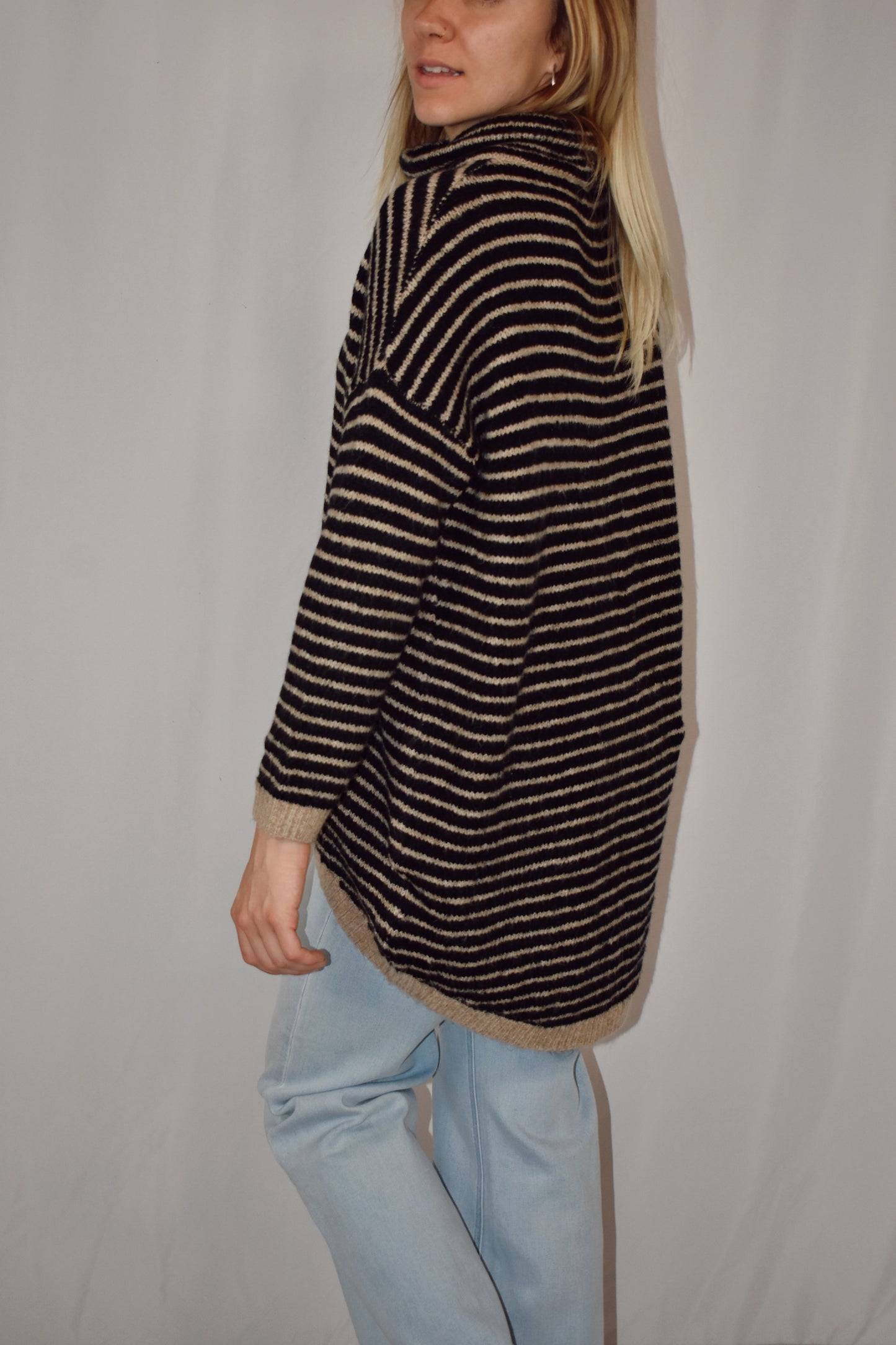 Pullover turtleneck striped sweater. Drop shoulder long sleeves, ribbed hem and sleeve cuffs, and high-low rounded hem. Black and taupe color.