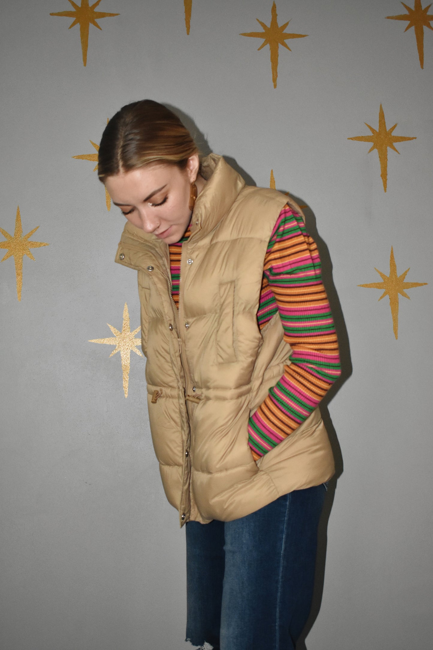Lightweight zip up puffer vest with sinch drawstring around waist for adjustable fit. 4 pockets. khaki.