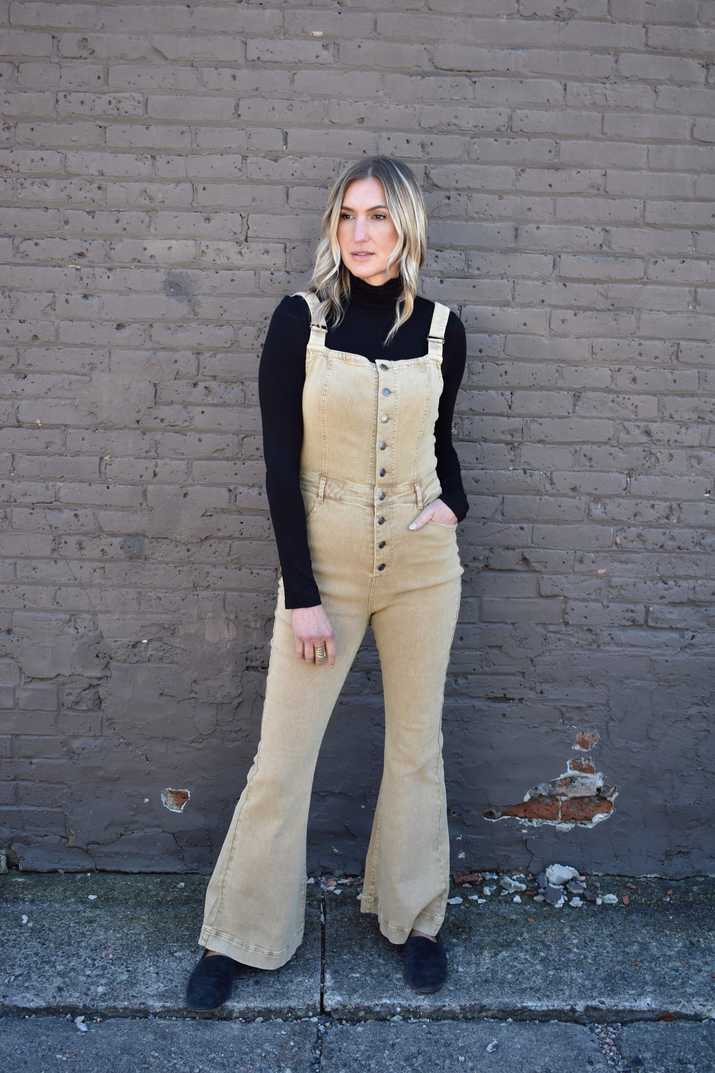 tan fitted denim overalls with bell bottoms and buttons down the front. waistline band has beltloops and front and back pockets. Adjustable straps.