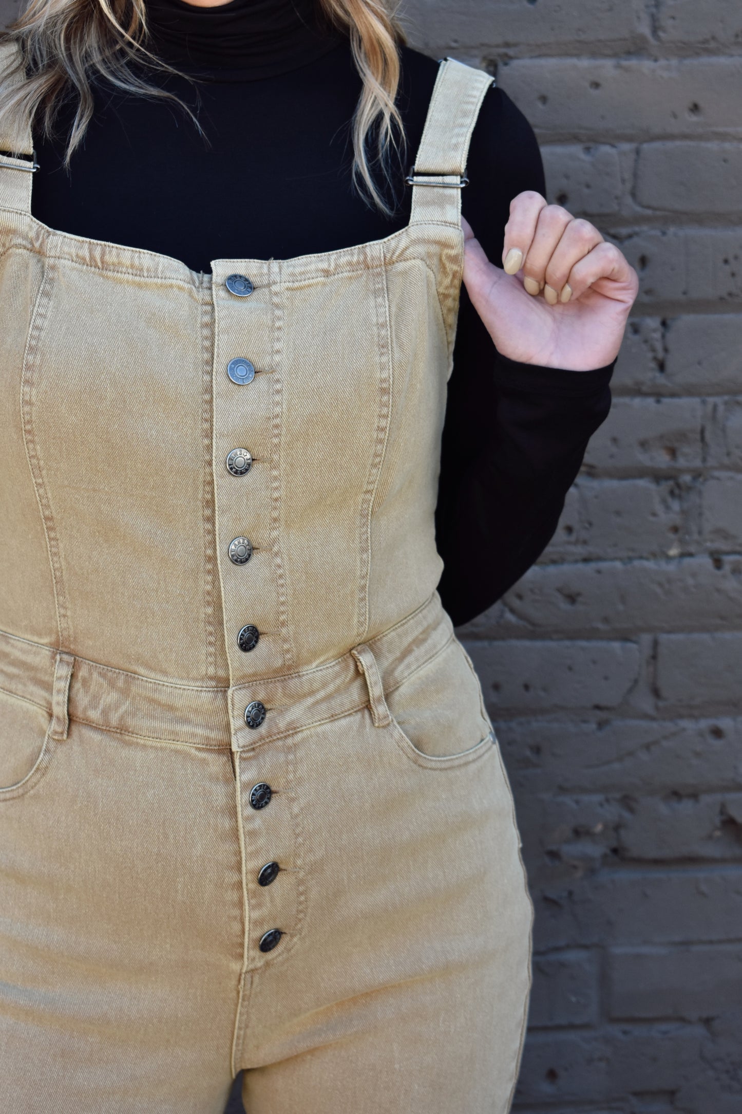tan fitted denim overalls with bell bottoms and buttons down the front. waistline band has beltloops and front and back pockets. Adjustable straps.