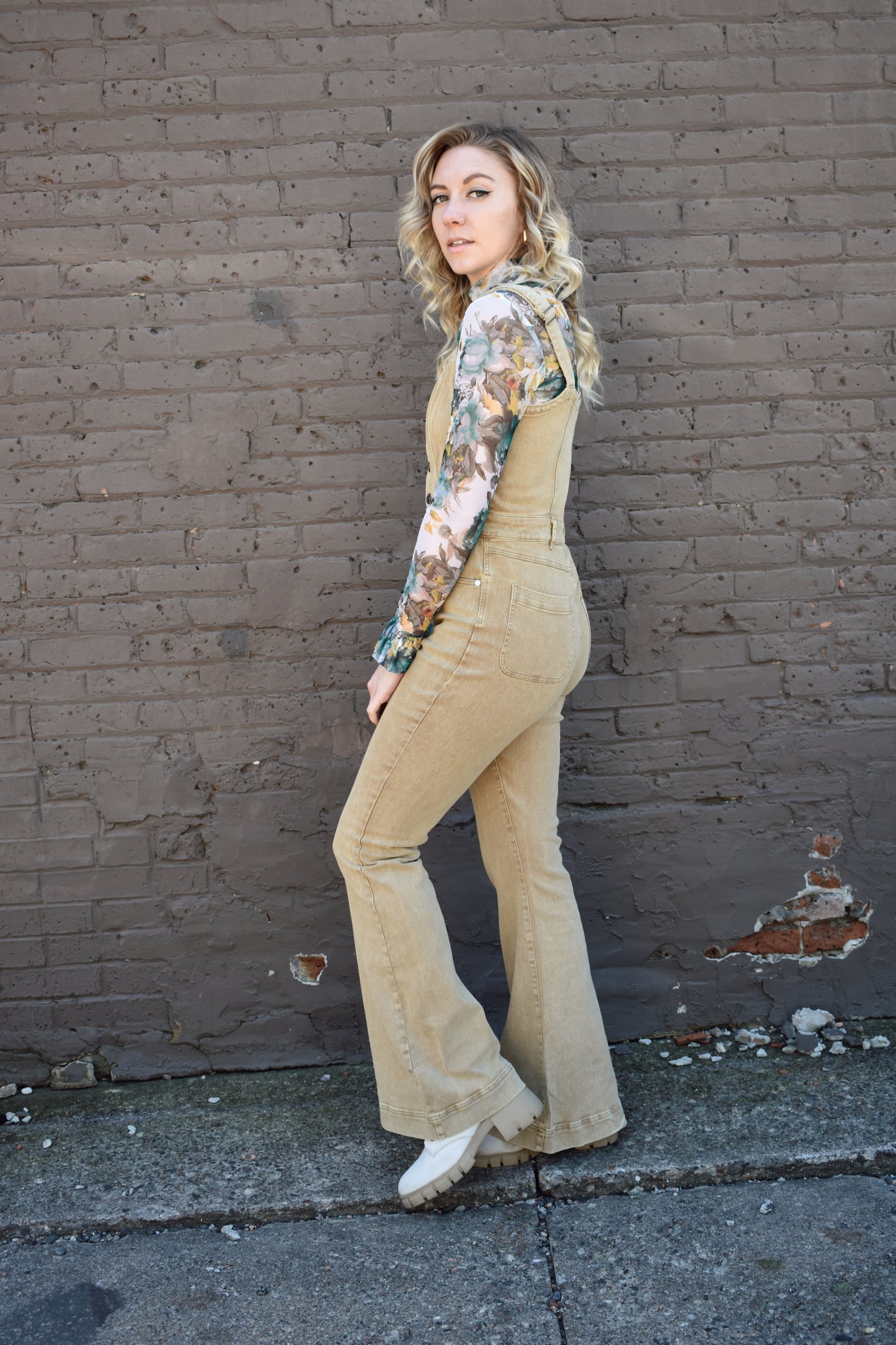 tan fitted denim overalls with bell bottoms and buttons down the front. waistline band has beltloops and front and back pockets. Adjustable straps.