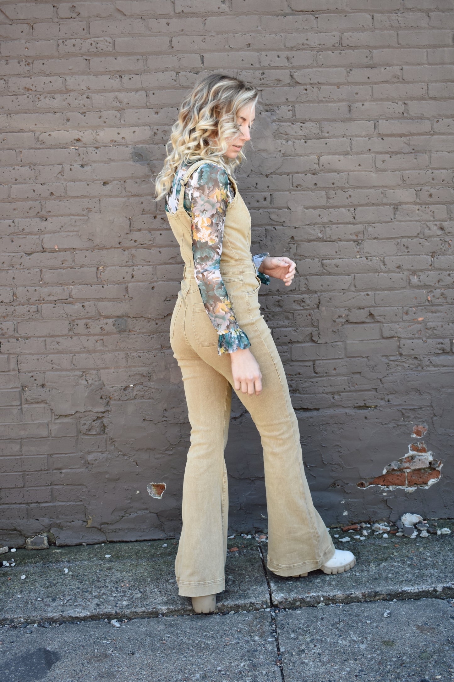 tan fitted denim overalls with bell bottoms and buttons down the front. waistline band has beltloops and front and back pockets. Adjustable straps.