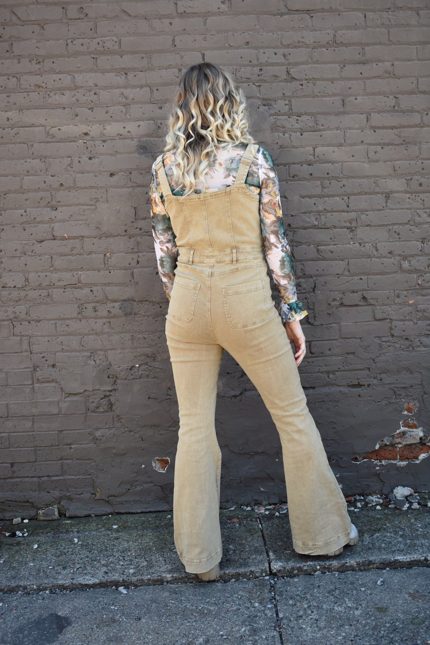 tan fitted denim overalls with bell bottoms and buttons down the front. waistline band has beltloops and front and back pockets. Adjustable straps.
