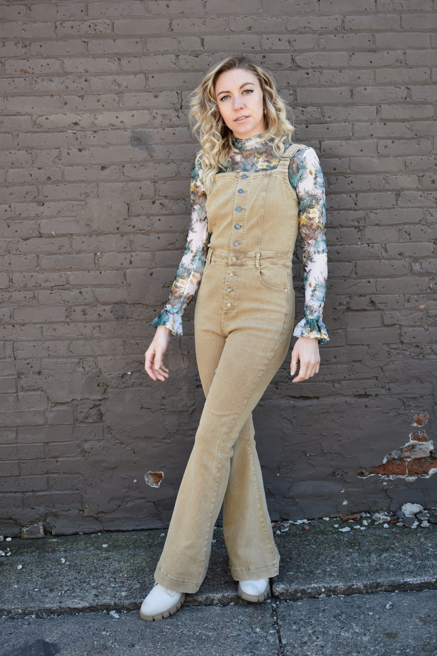 tan fitted denim overalls with bell bottoms and buttons down the front. waistline band has beltloops and front and back pockets. Adjustable straps.