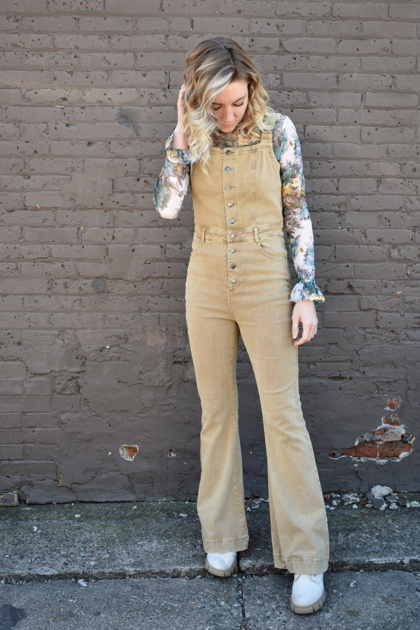 tan fitted denim overalls with bell bottoms and buttons down the front. waistline band has beltloops and front and back pockets. Adjustable straps.