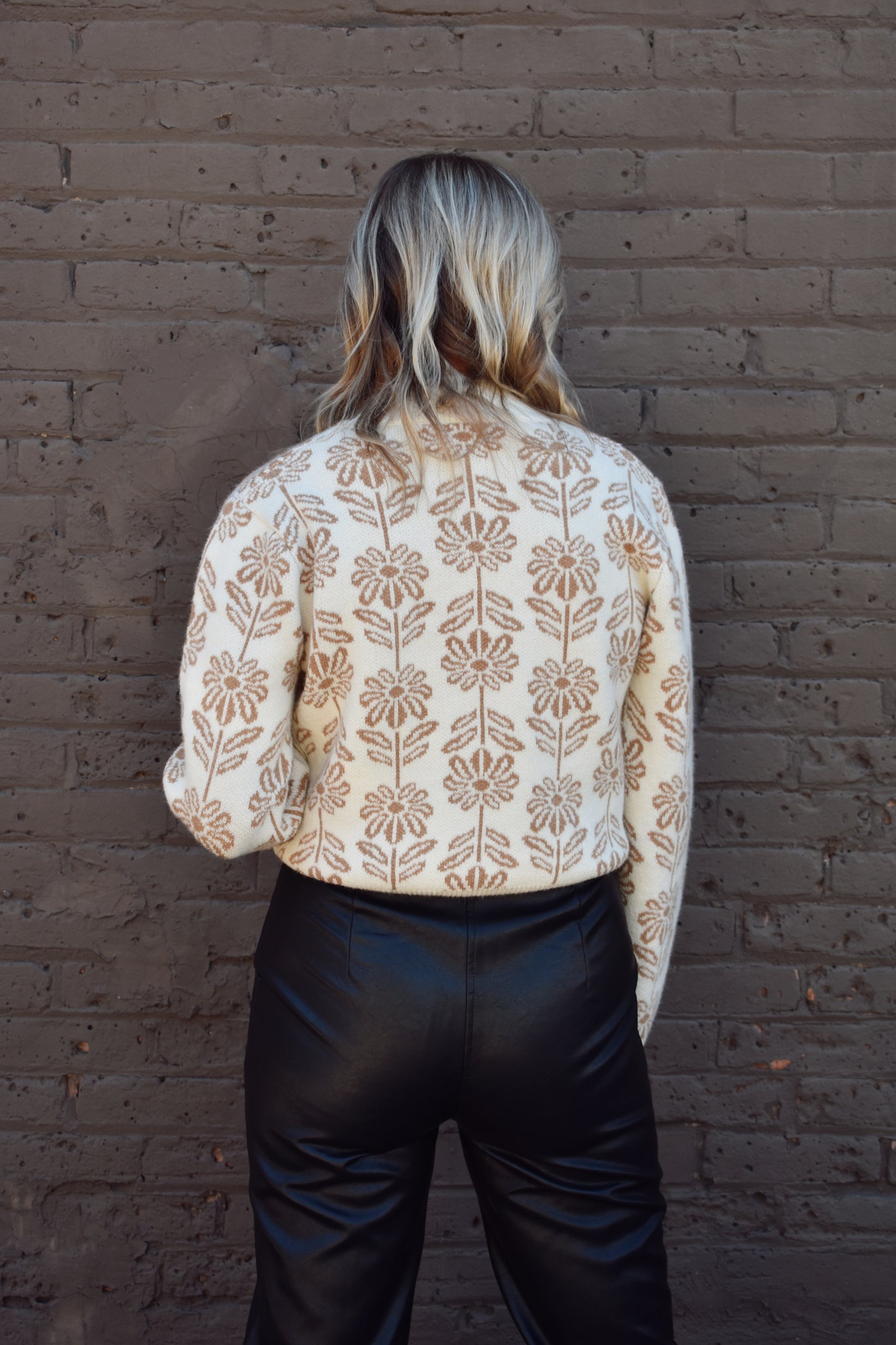 taupe and cream floral pattern knit sweater with ribbed high round neckline, hem, and cuffs.