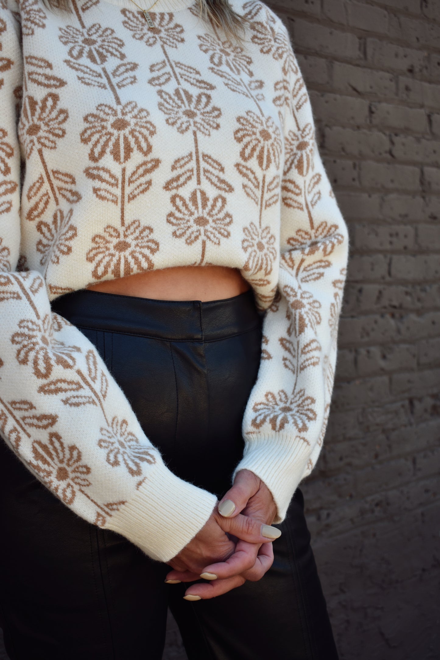 taupe and cream floral pattern knit sweater with ribbed high round neckline, hem, and cuffs.