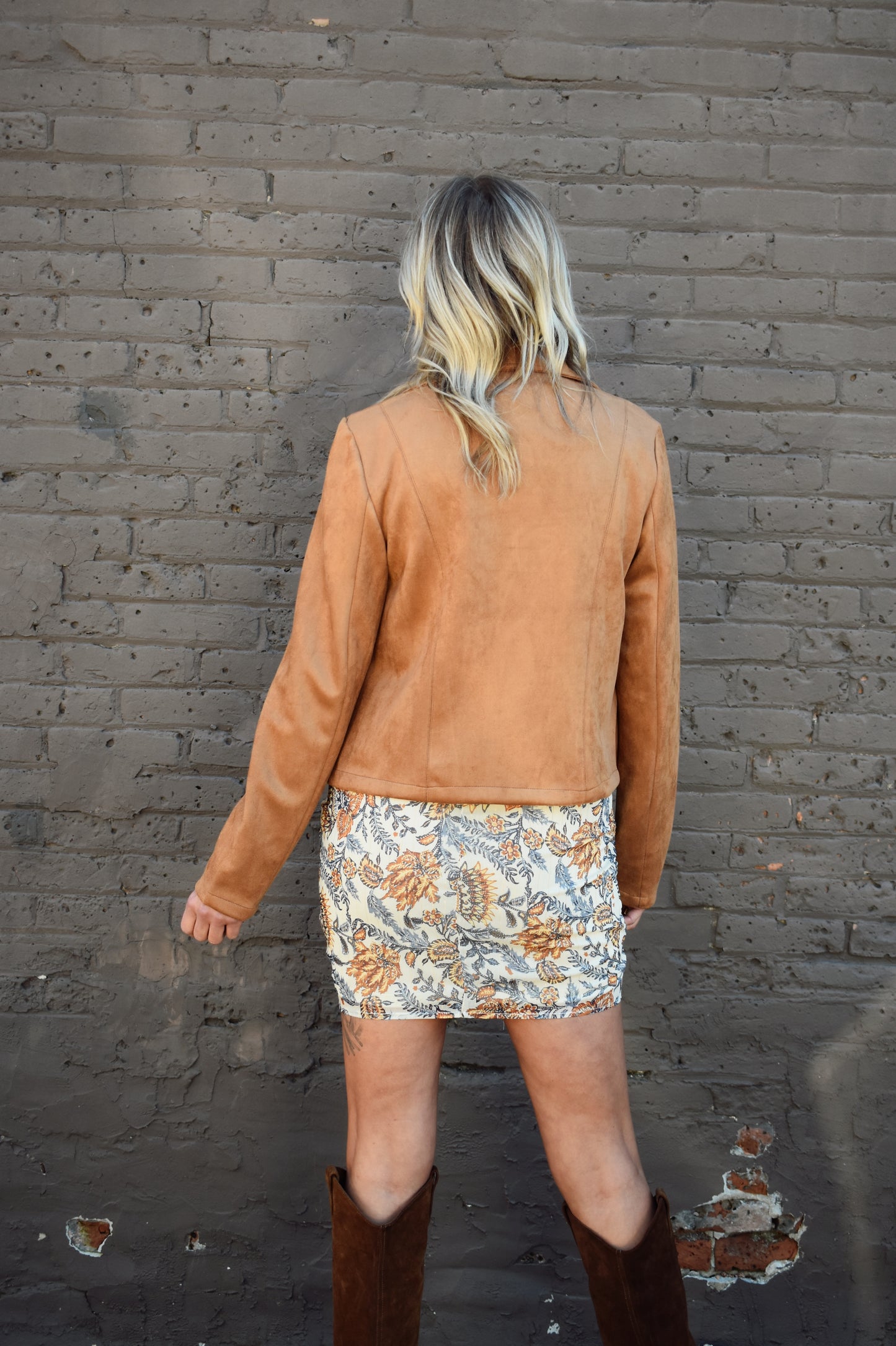stretchy vegan suede moto jacket in a camel color with zipper enclosure and zippered pockets.