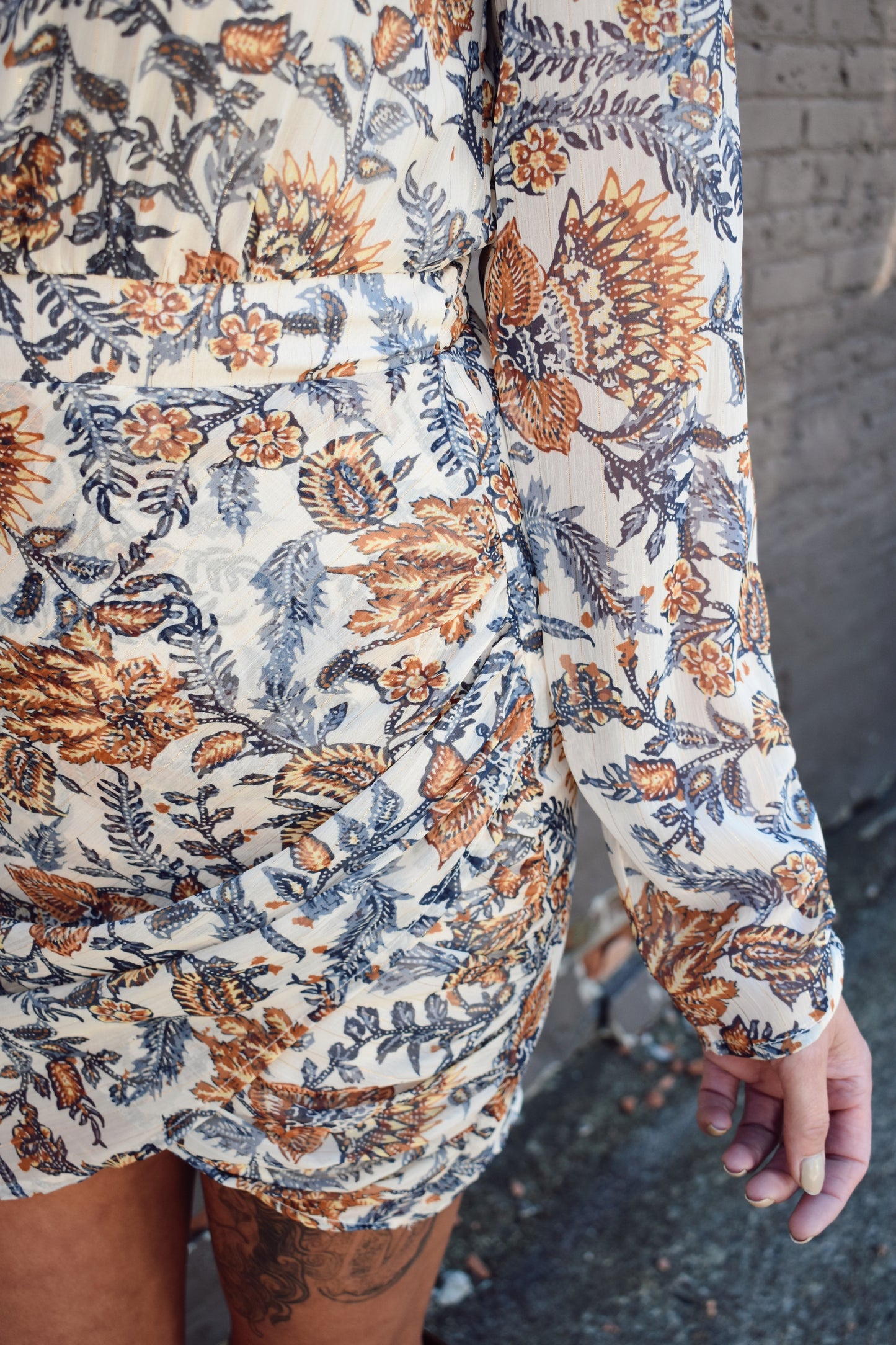 blue and taupe floral printed long sleeve mini dress with ivory background. Wrap skirt. mock neck with tie.