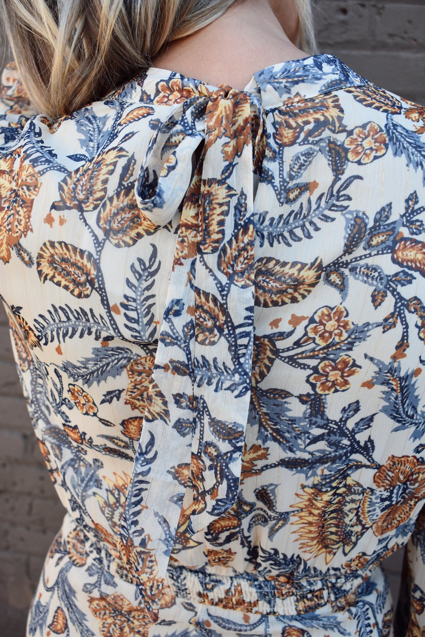 blue and taupe floral printed long sleeve mini dress with ivory background. Wrap skirt. mock neck with tie.
