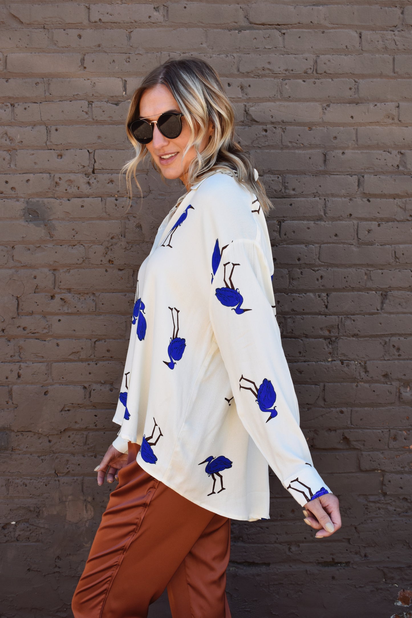 White relaxed fit button down with blue birds printed on it. High low hem. Drop shoulders.