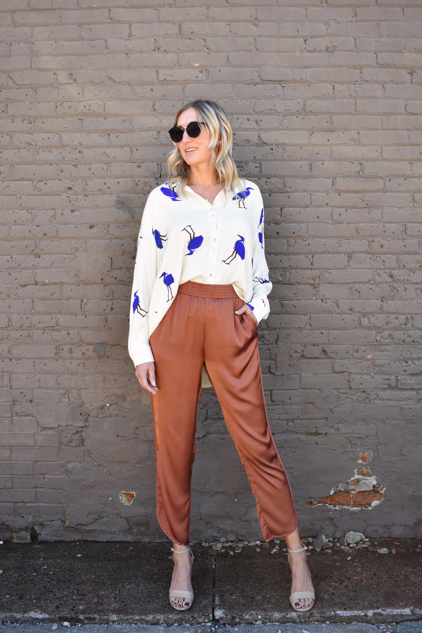 Copper colored satin joggers with side pockets and elastic waistband. rounded tulip hem with welted side seams.