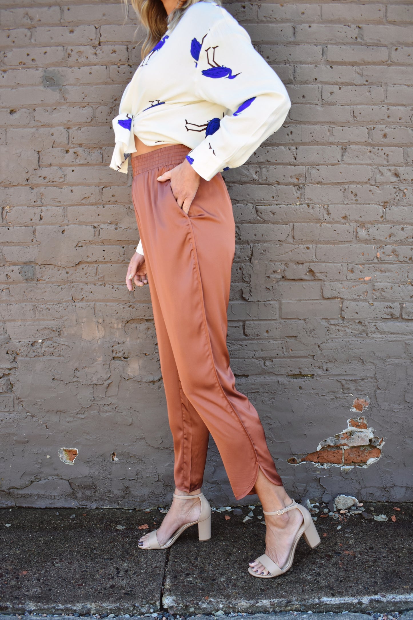 Copper colored satin joggers with side pockets and elastic waistband. rounded tulip hem with welted side seams.