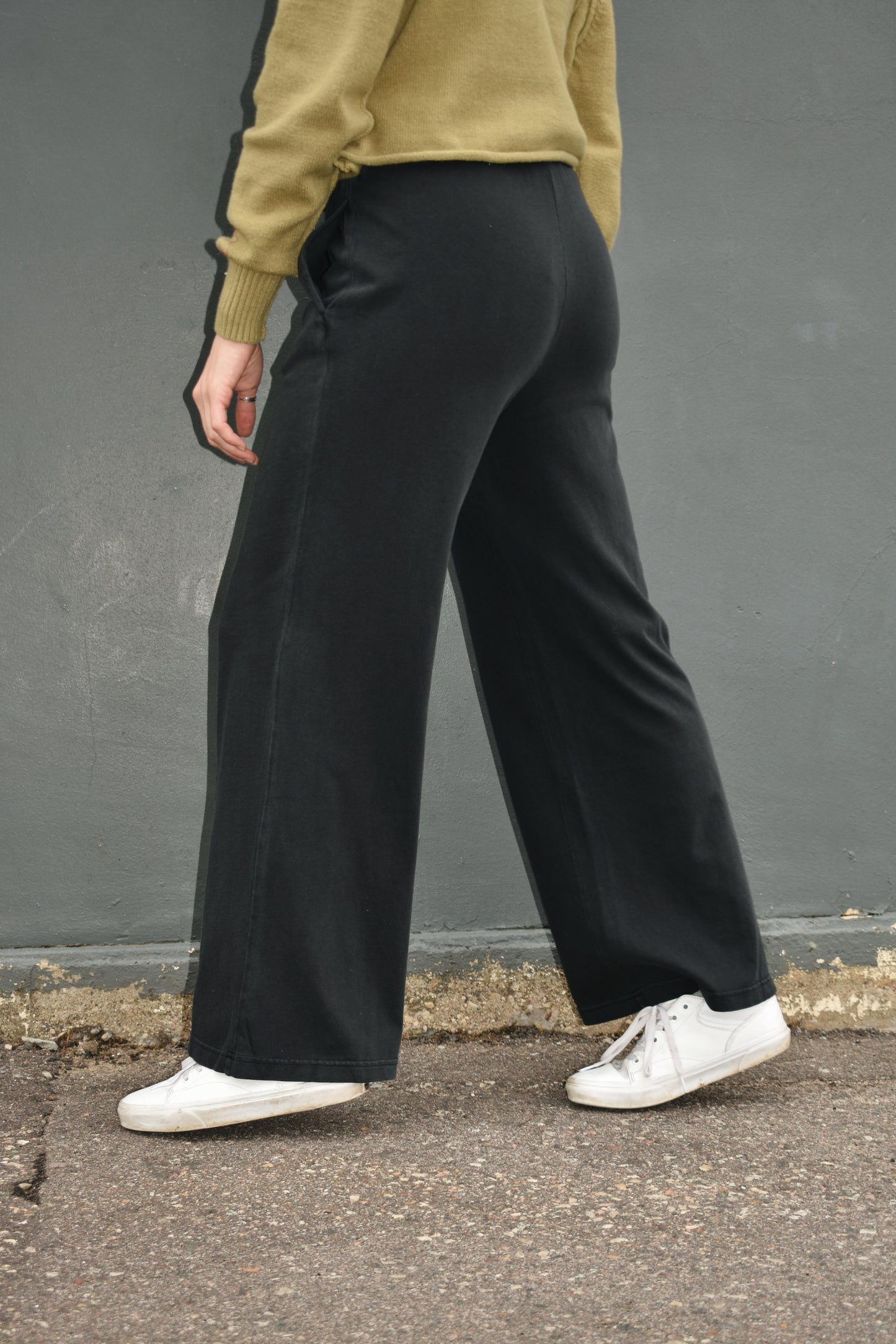 black wide leg athleisure pants with elastic waistband with drawstring, pockets and seam detail down the front of the legs.