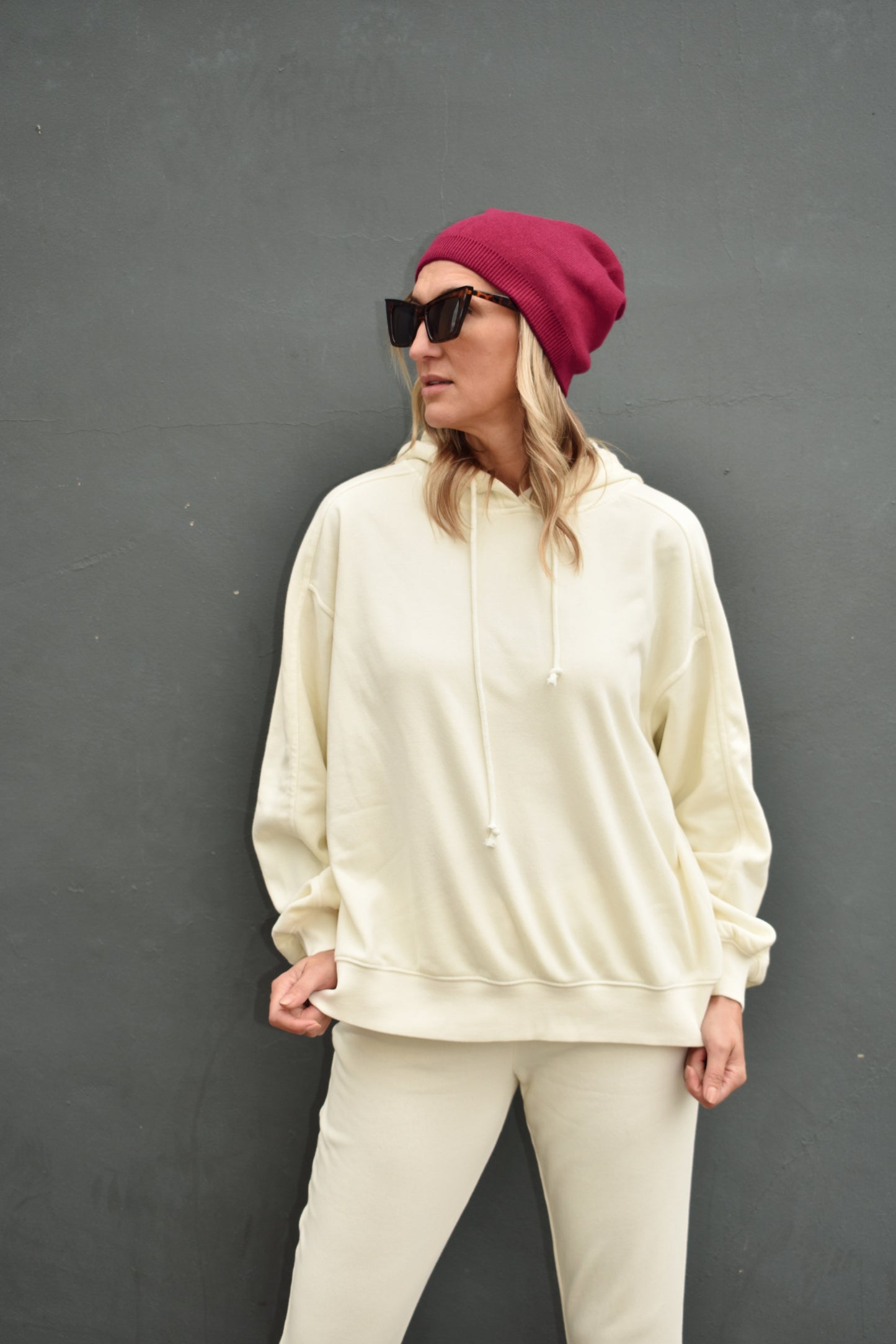 Cream full length hoodie with drop shoulders, drawstrings, and ribbed cuffs. loose fitting.