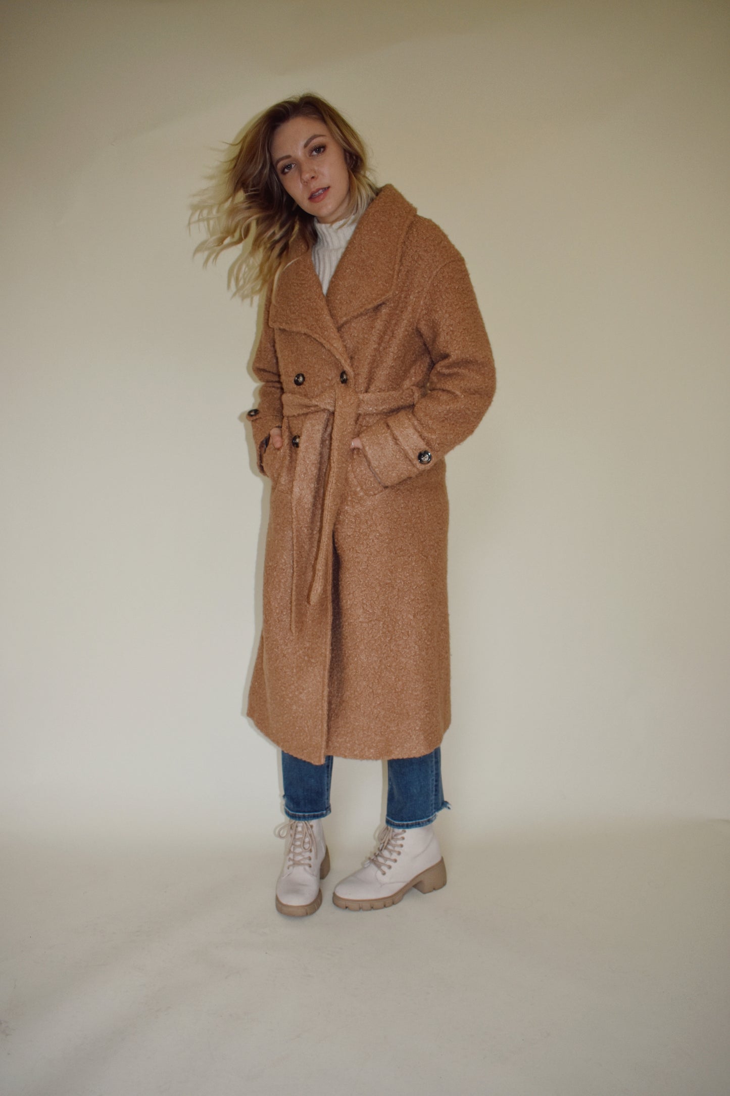 Teddy trench coat in camel with waterfall collar and belt loops with tie, double button closure, long sleeves come fitted with toggle buttons, slit back hem, pockets