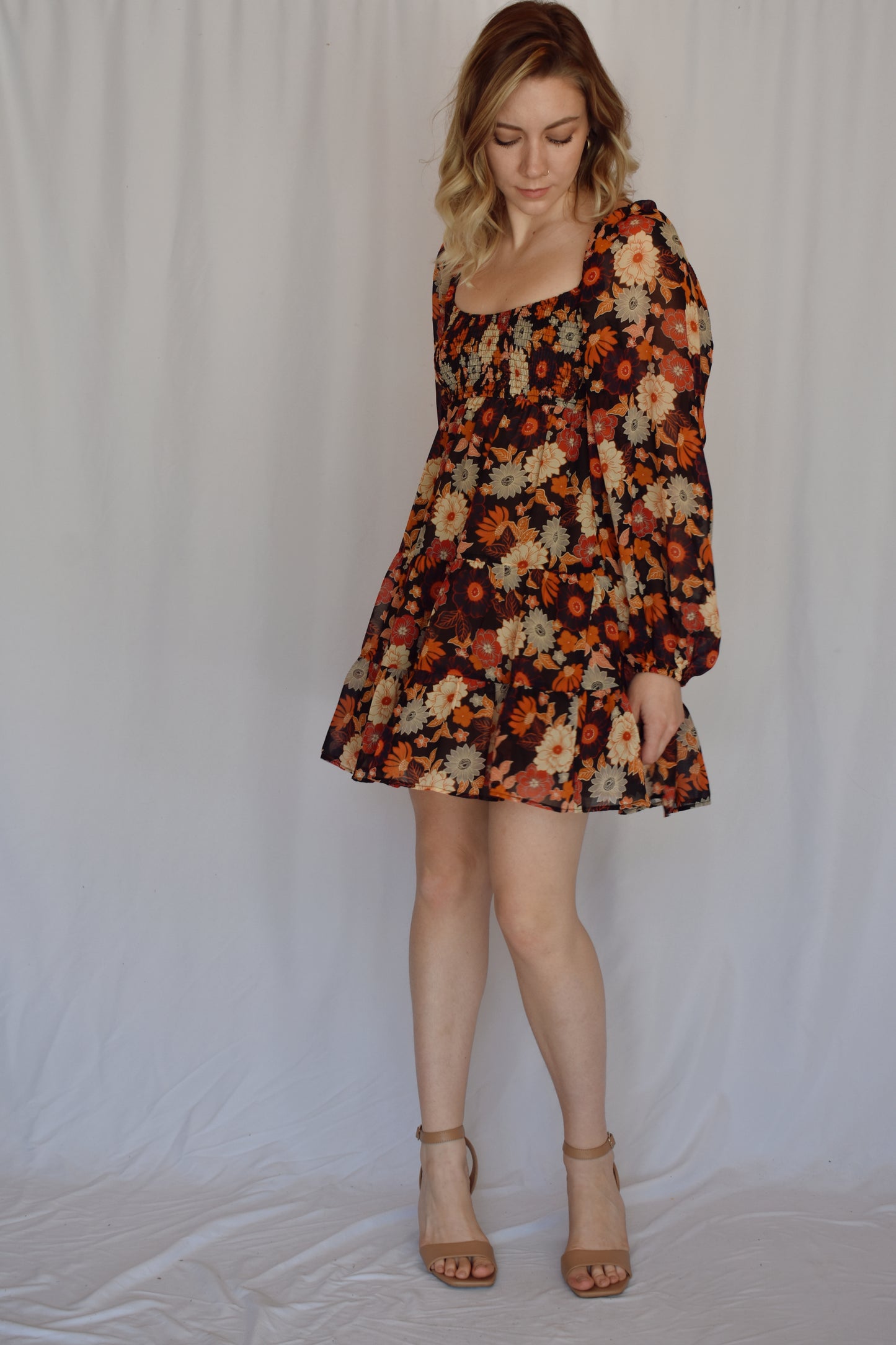 autumn colored floral swing mini dress with tiered skirt and smocked bust with a square neckline thats mirrored on the back with bubble puff sheer long sleeves with elastic synching at wrist