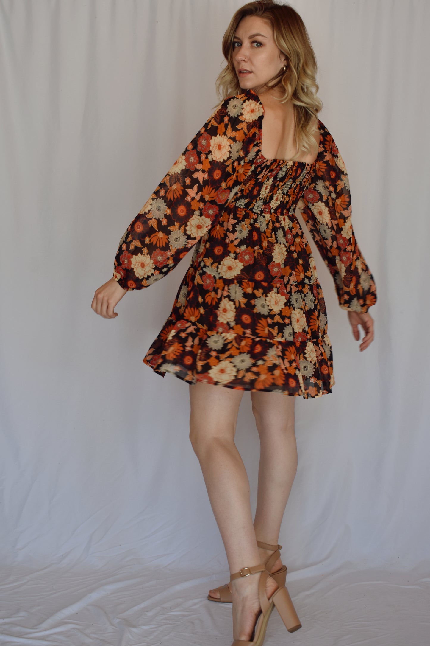 autumn colored floral swing mini dress with tiered skirt and smocked bust with a square neckline thats mirrored on the back with bubble puff sheer long sleeves with elastic synching at wrist