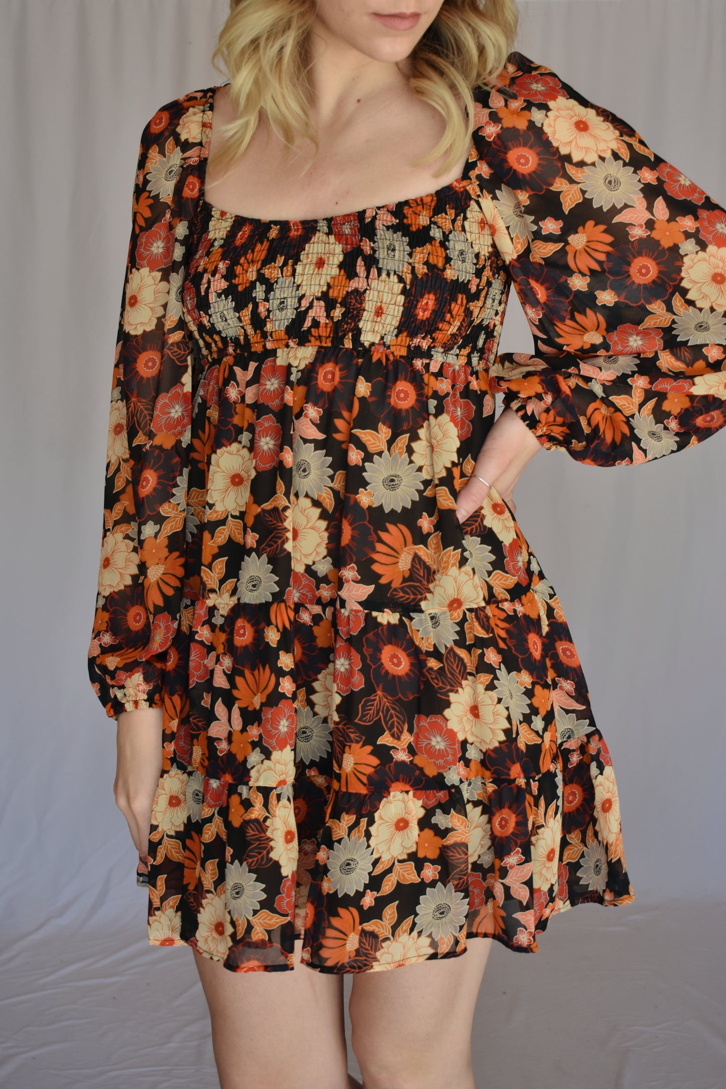 autumn colored floral swing mini dress with tiered skirt and smocked bust with a square neckline thats mirrored on the back with bubble puff sheer long sleeves with elastic synching at wrist