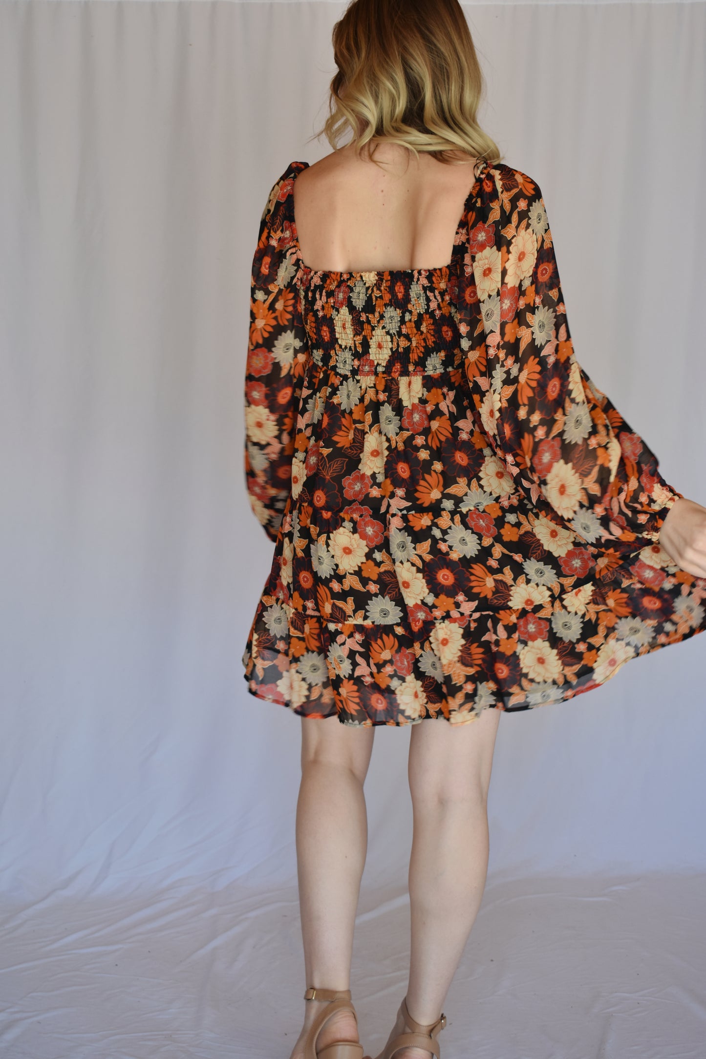 autumn colored floral swing mini dress with tiered skirt and smocked bust with a square neckline thats mirrored on the back with bubble puff sheer long sleeves with elastic synching at wrist