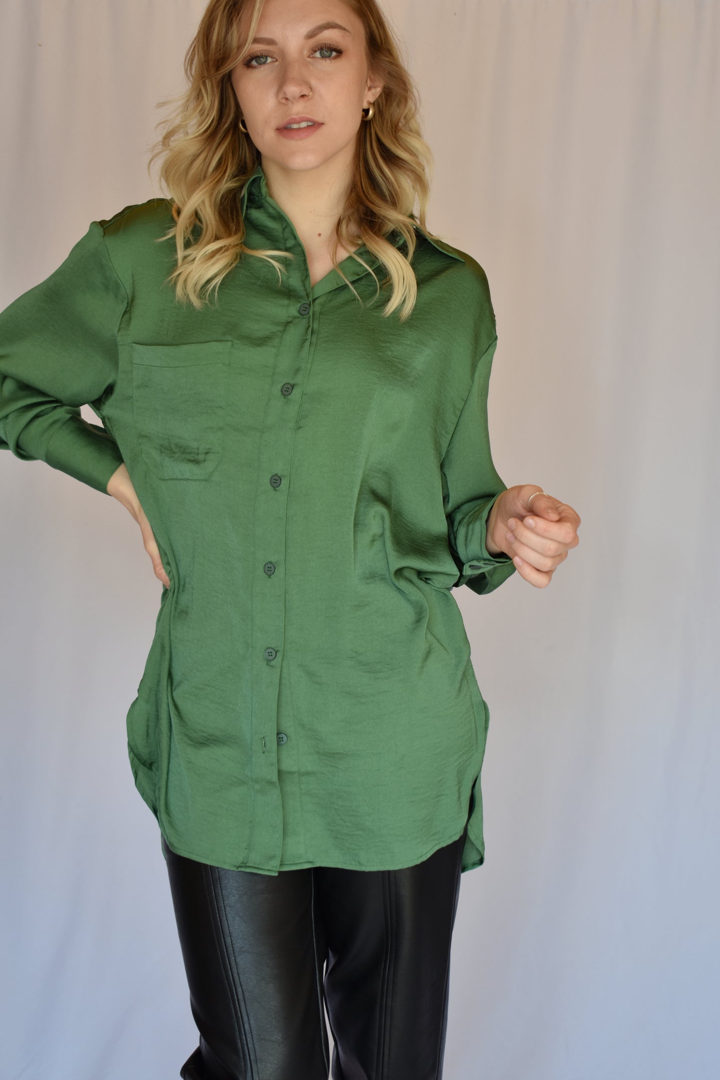 button down satin green tunic with button cuffs and one breast pocket and drop shoulders. Relaxed fit.