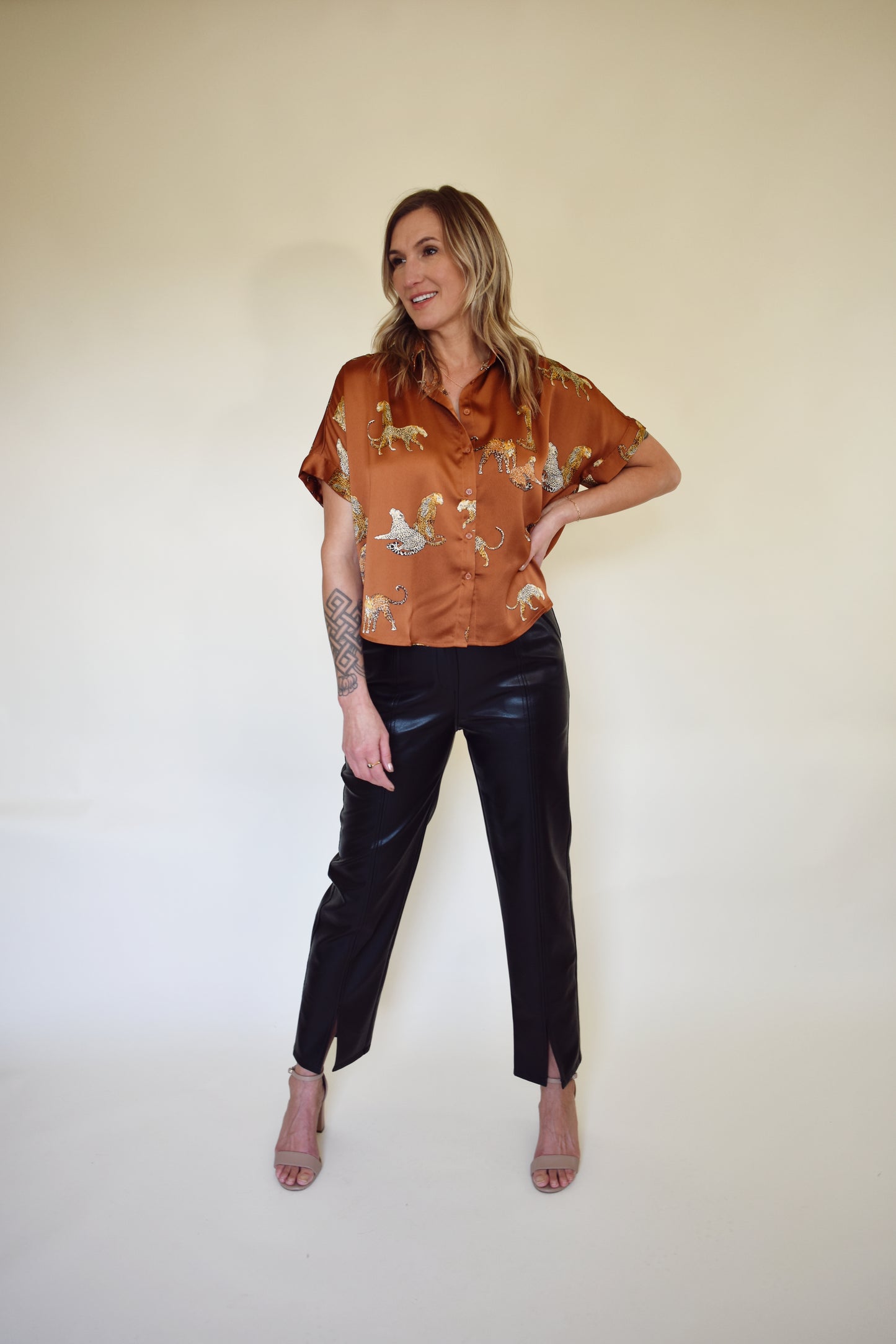 Satin drop shoulder short sleeve button down with rounded hem. flowy fit, not oversized. copper color with leopards